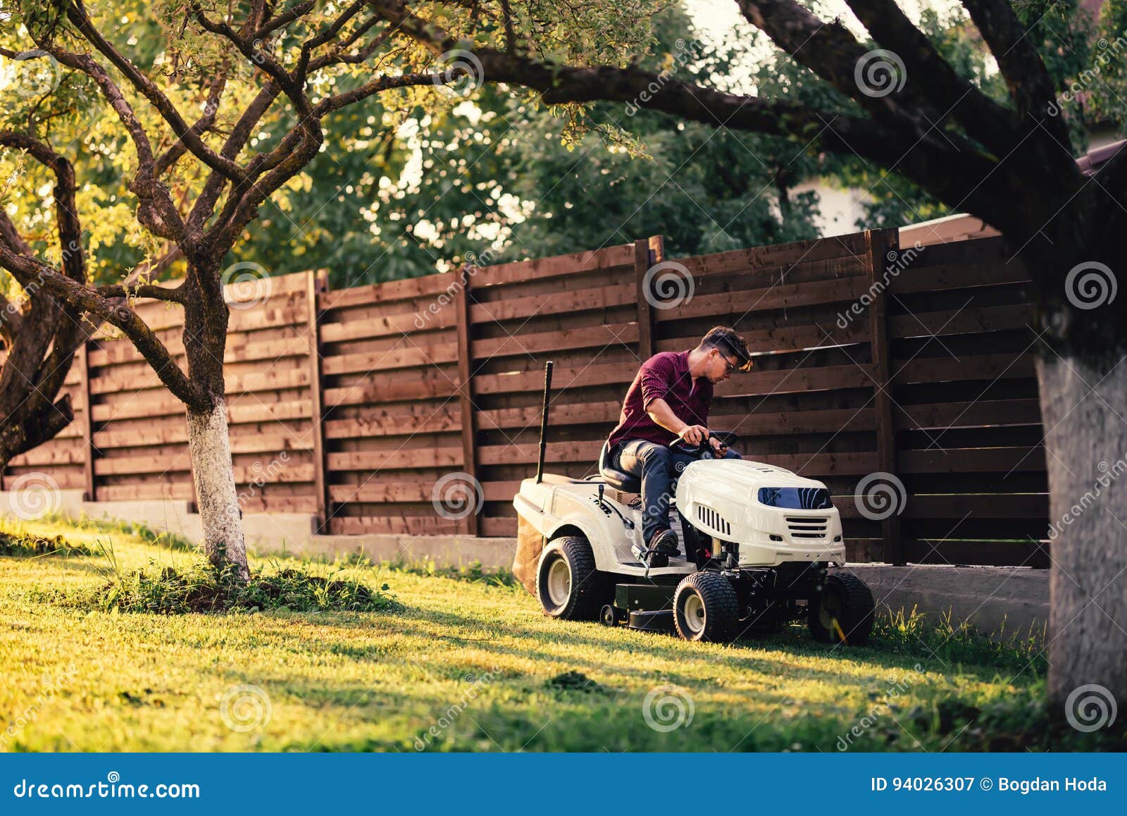 Man Using Lawn Tractor for Mowing Grass. Landscaping Works with