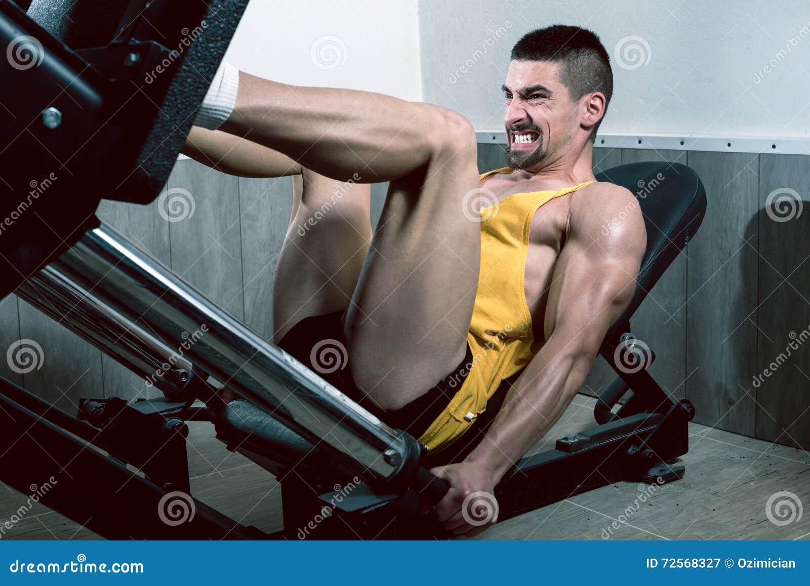 Man using leg press in gym stock image. Image of center 72568327