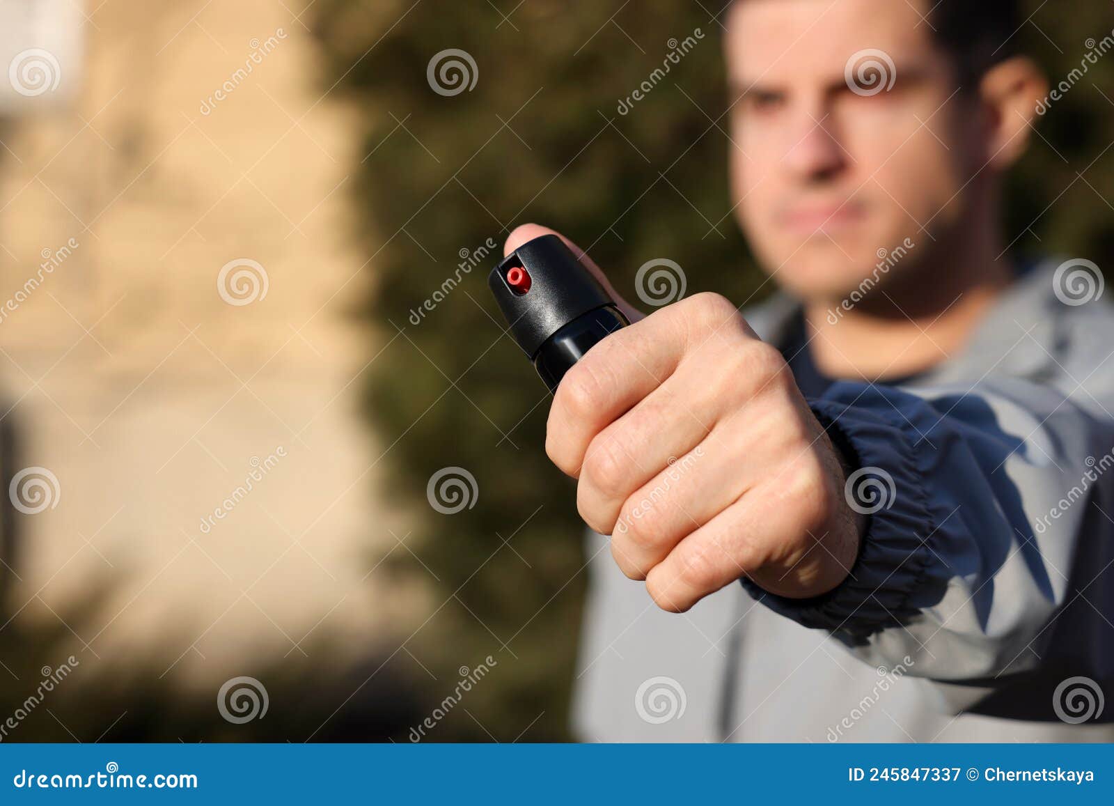 Man Using Pepper Spray Outdoors, Focus on Hand. Space for Text Stock