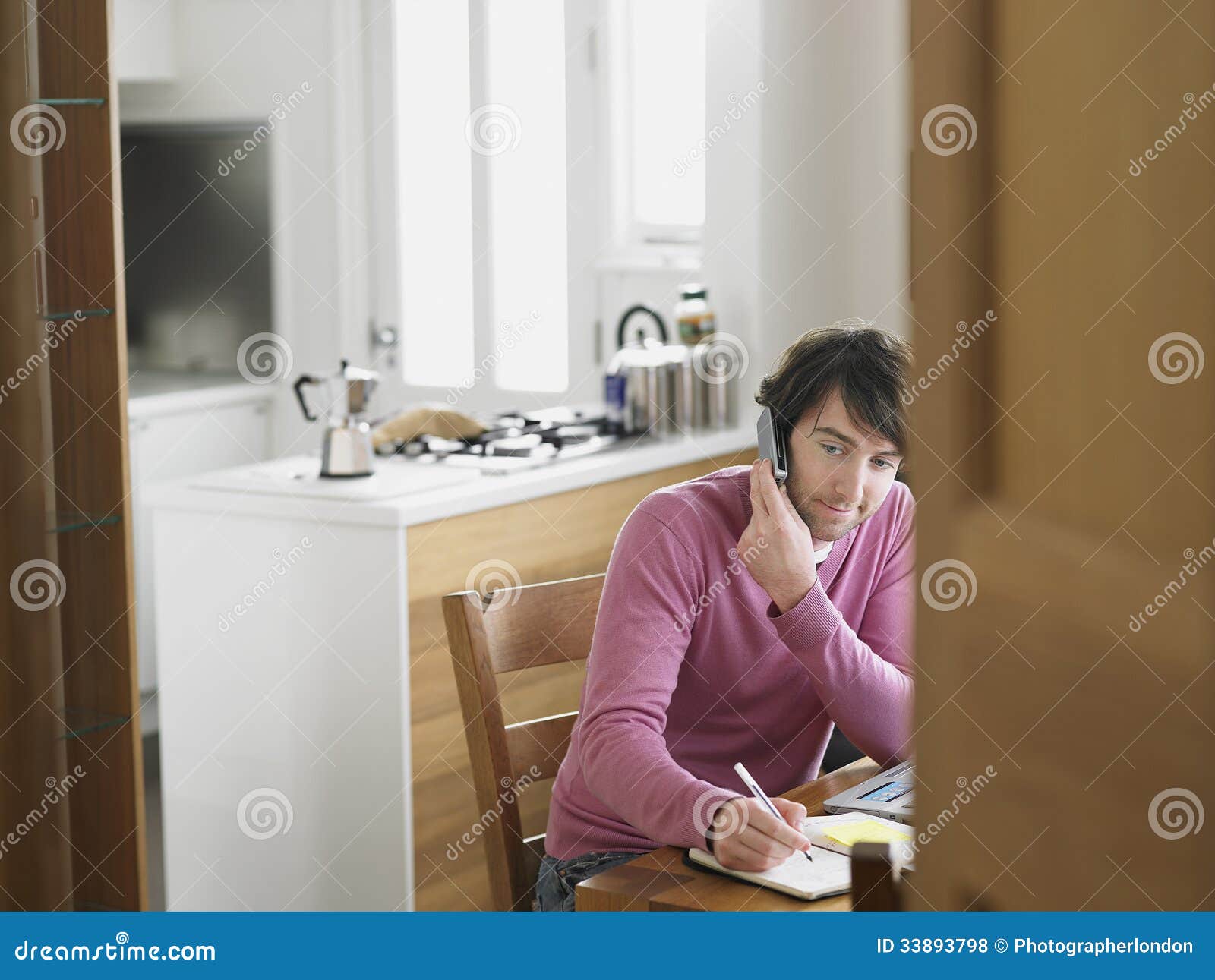 Man Using Phone at Kitchen Table Stock Photo Image of chair, house