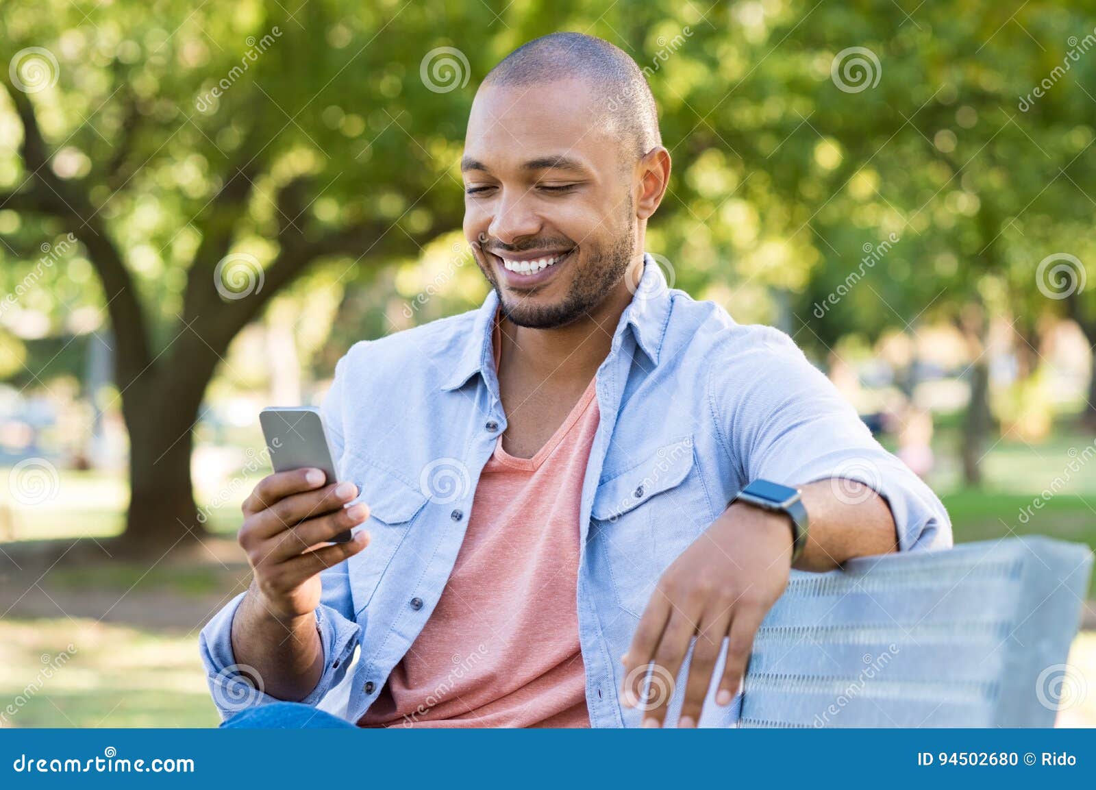 Young smiling African American man using mobile application for online  shopping on black Friday. Portrait of handsome businessman holding  cellphone Stock Photo - Alamy