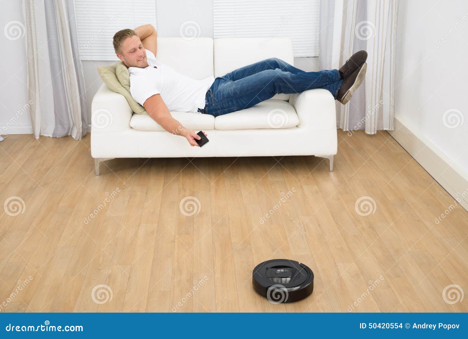 Robotic Vacuum Cleaner Runs On The Laminate And On The Tile Floor. The Robot Is Controlled By