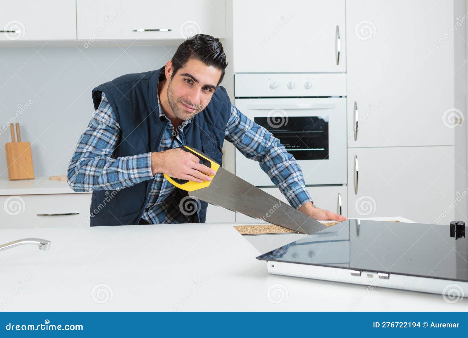 Man using saw in kitchen stock photo. Image of occupation 276722194