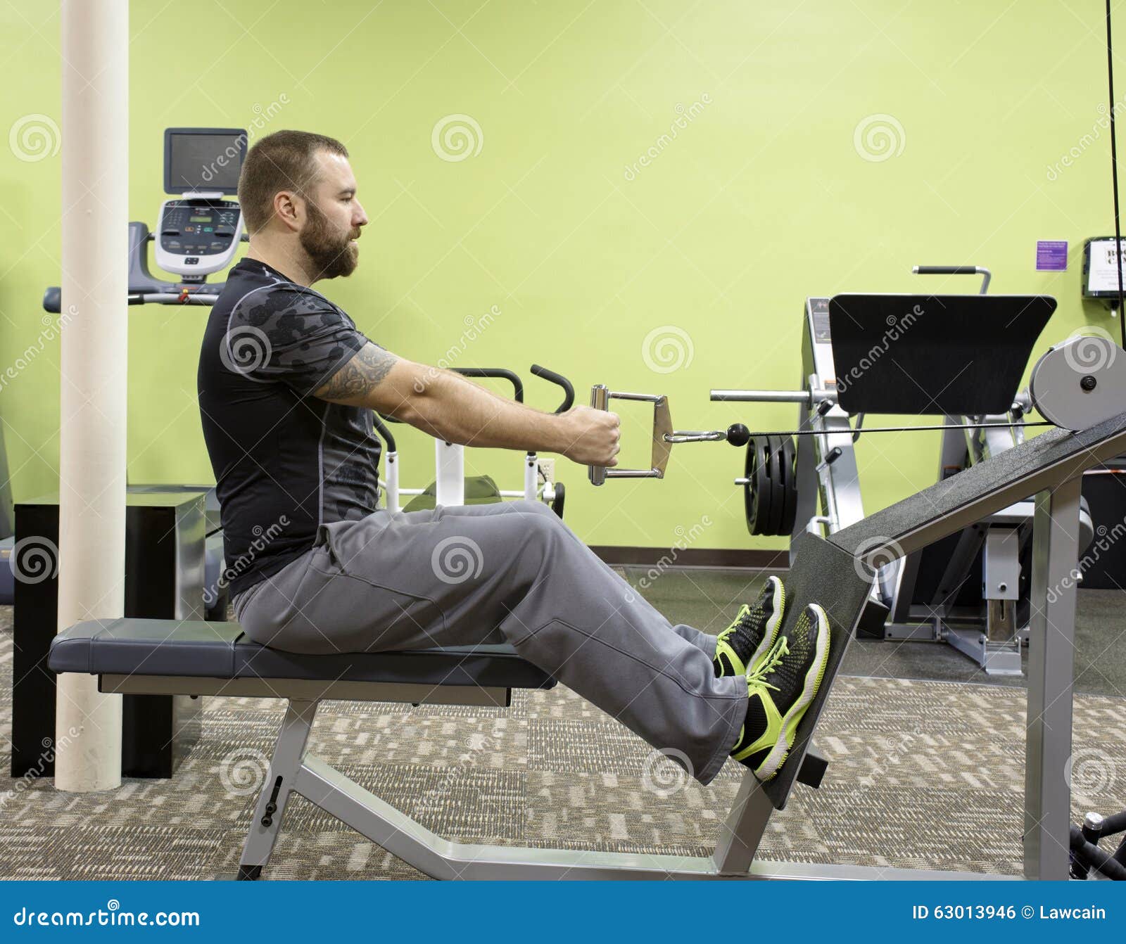 Man Using Seated Row Machine Stock Photo - Image of fitness, black