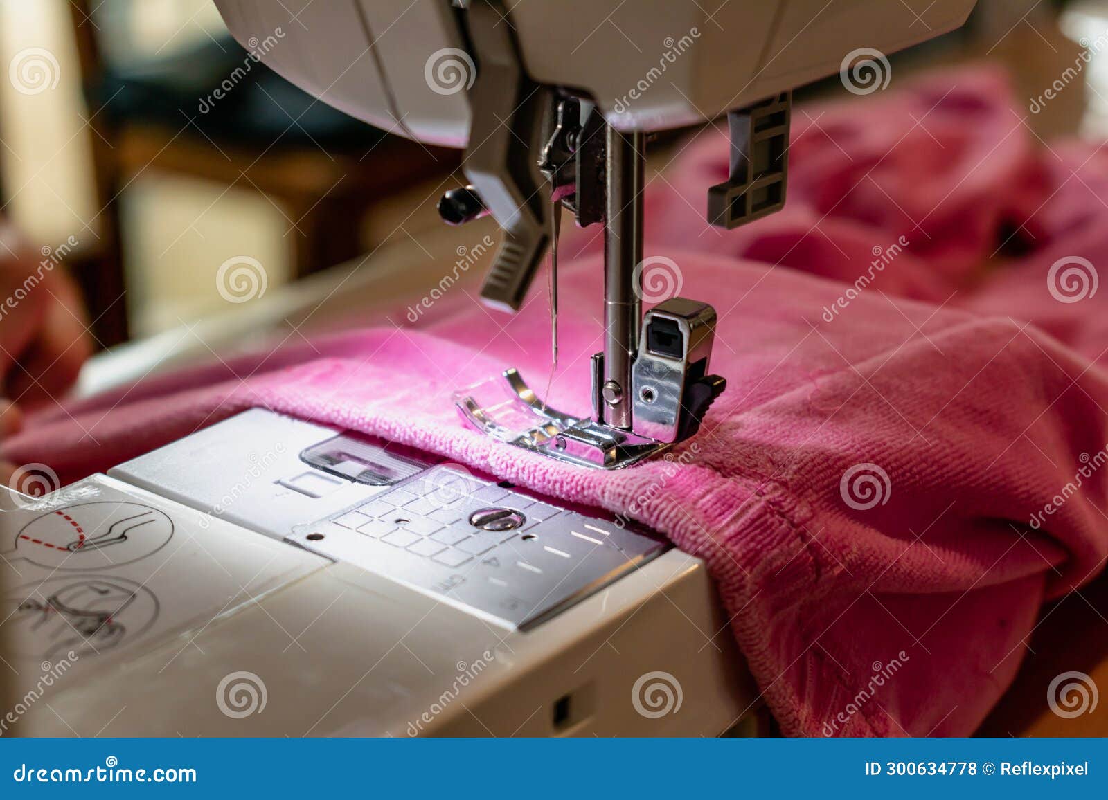 Man Using a Sewing Machine with a Pink Garment, for Repair Work
