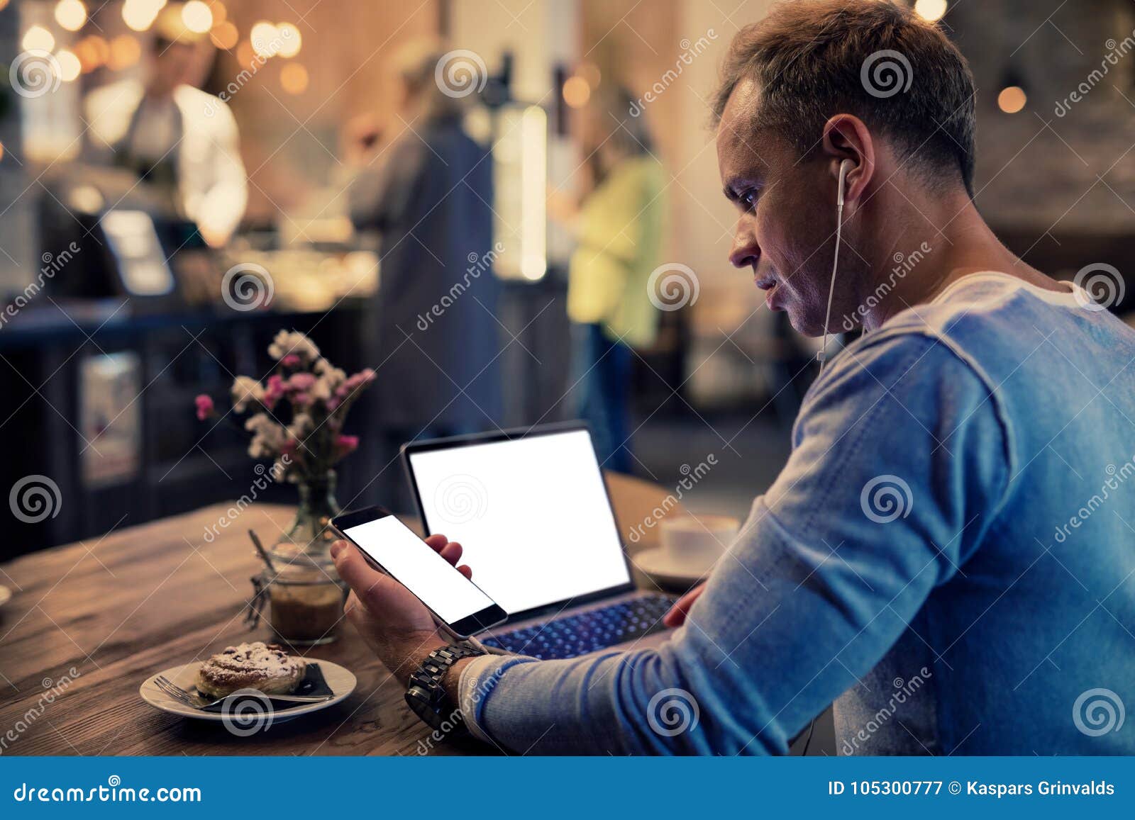 man using tech gadgets in cafe