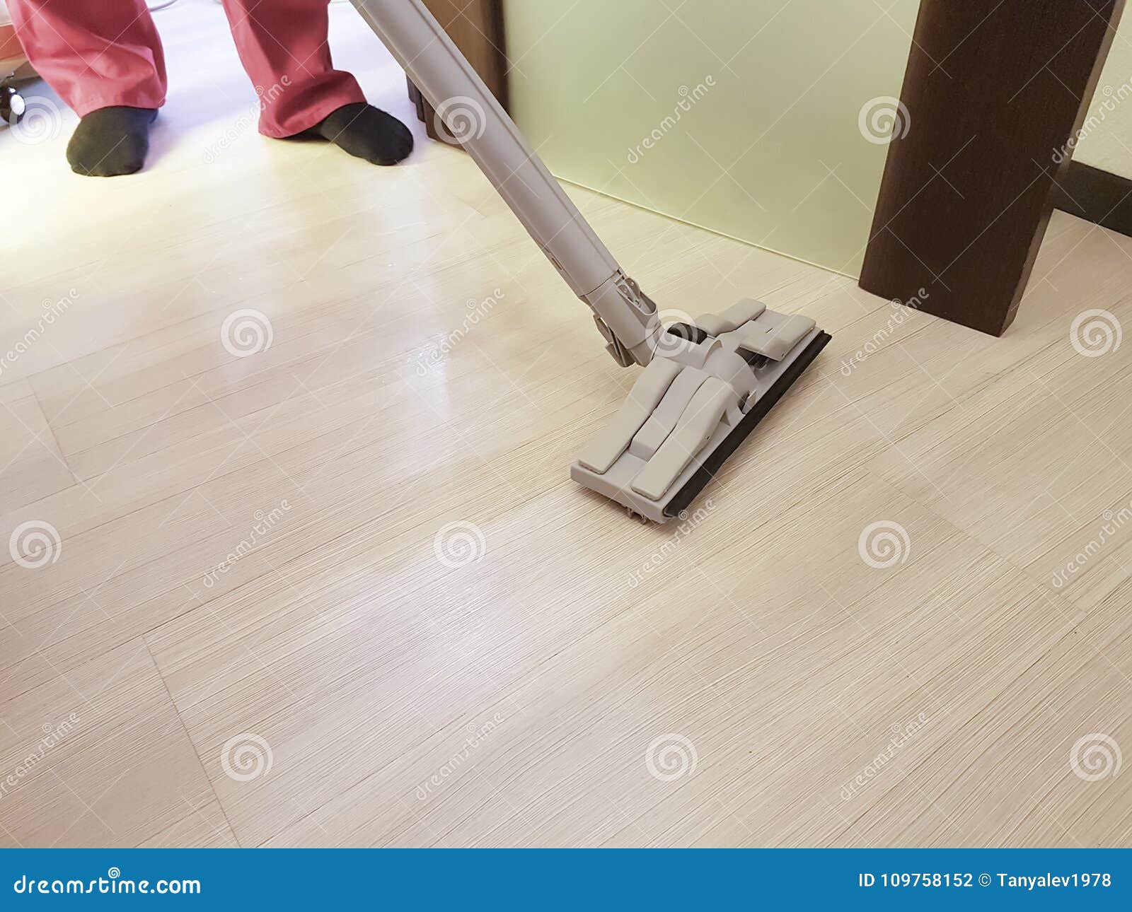 Man Vacuuming The Floor In The Room Cleaning Service Stock Photo