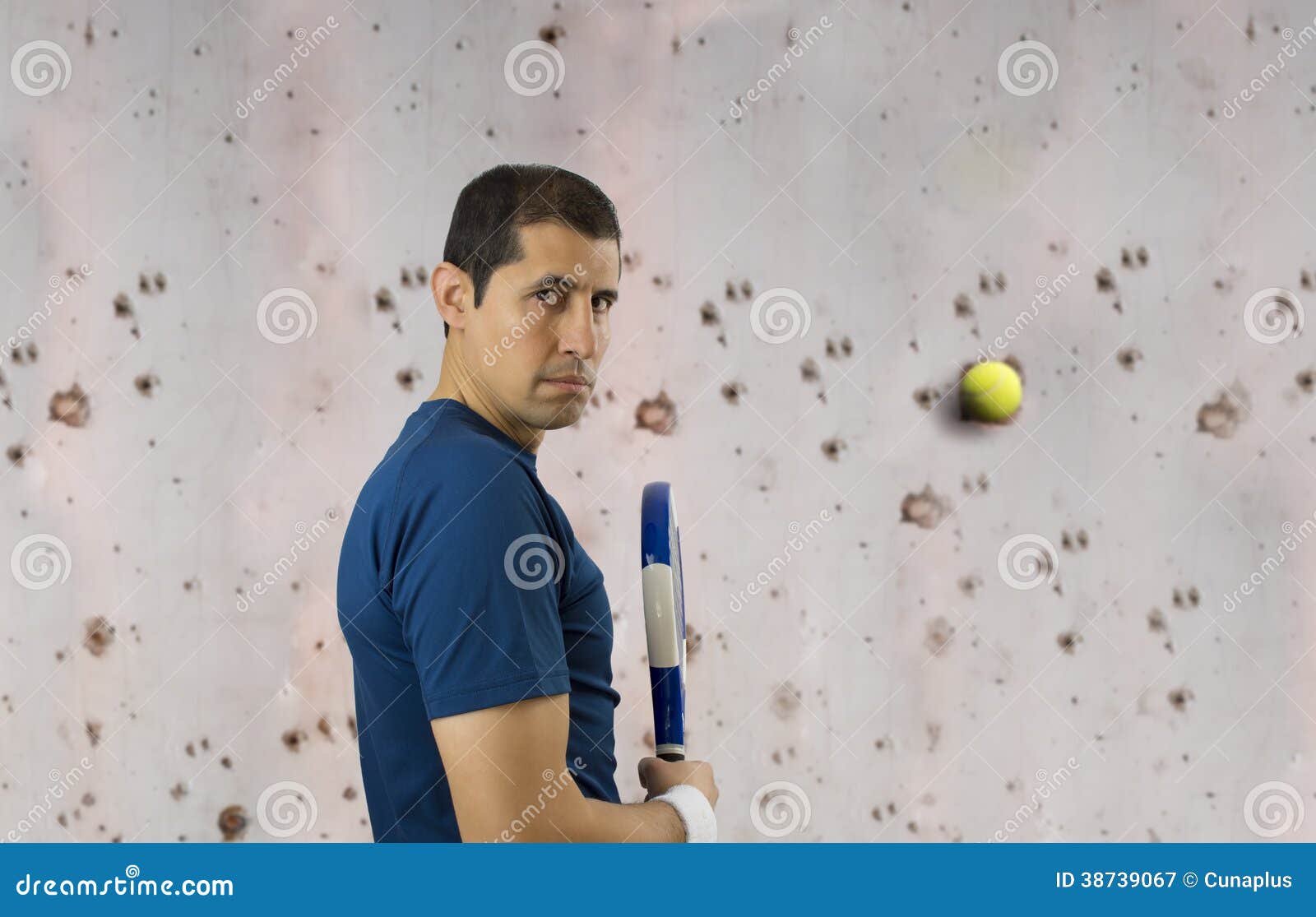 Man venting their anger against a wall. Man vents his anger with a wall with a ball and paddle racket