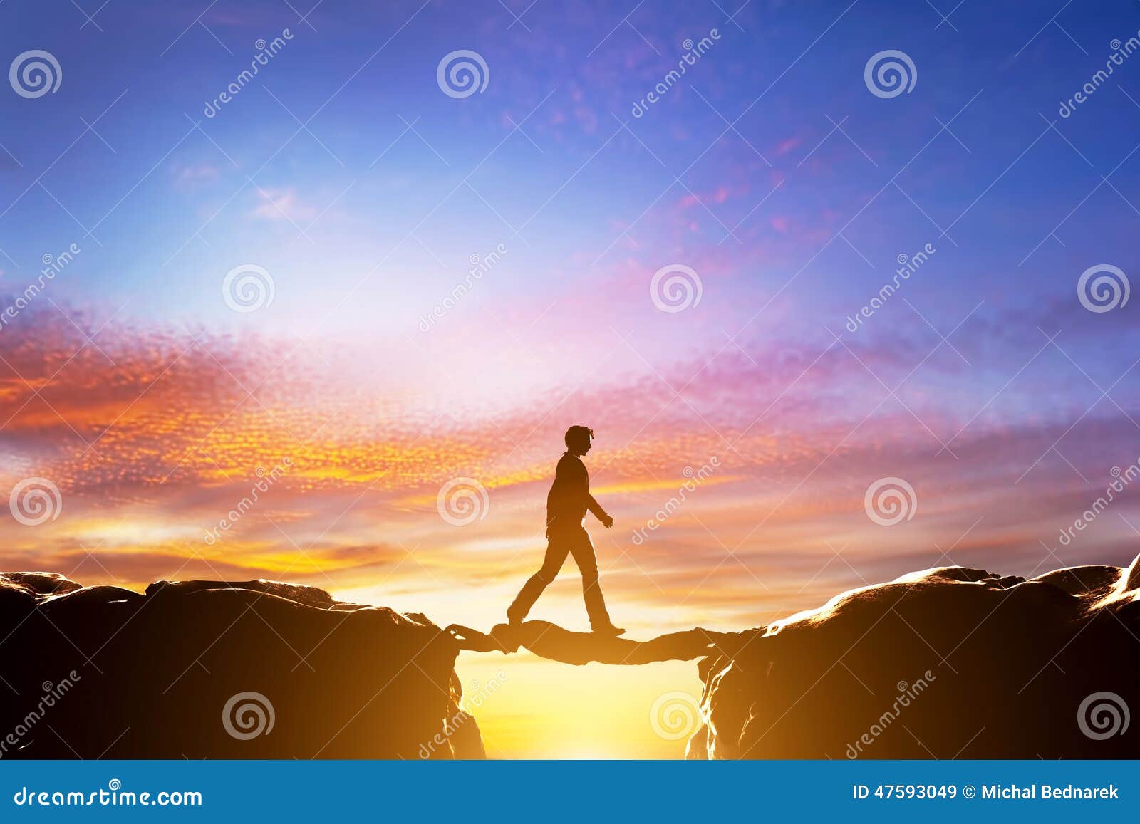 man walking on another man over precipice between mountains