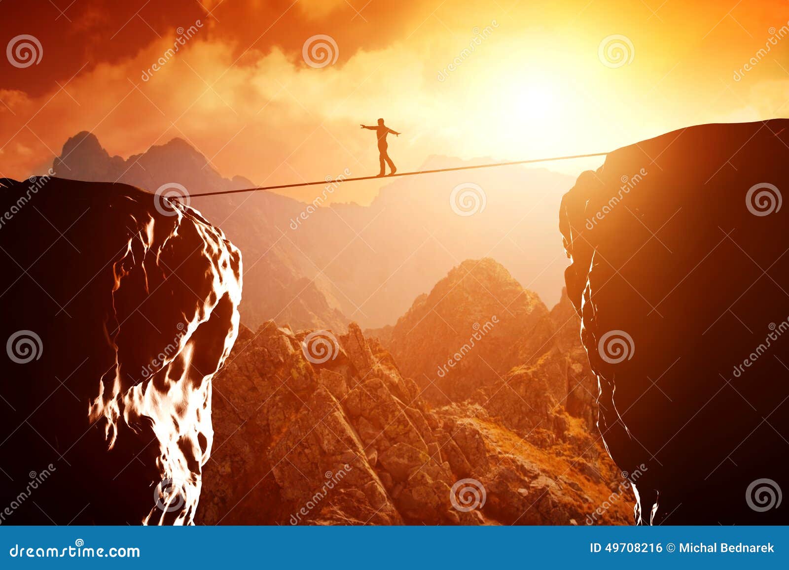 man walking and balancing on rope over precipice