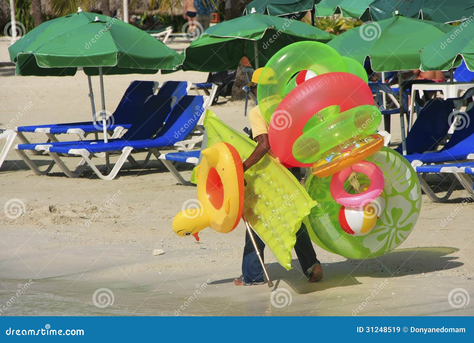 man walking with swim matresses and rings, boca chica beach