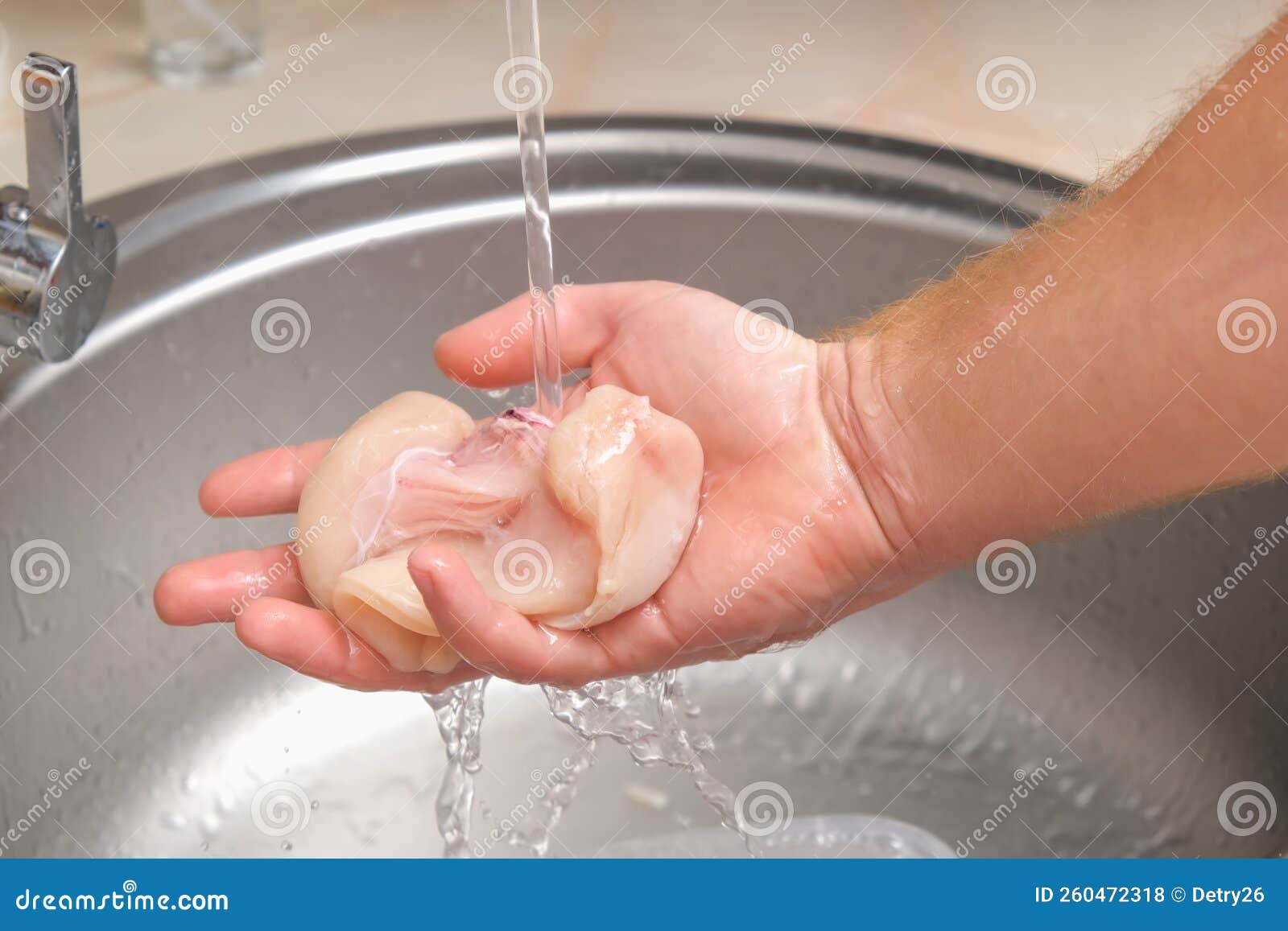 A Man Washes Defrosted Raw Chicken Fillet. Fresh Raw Chicken