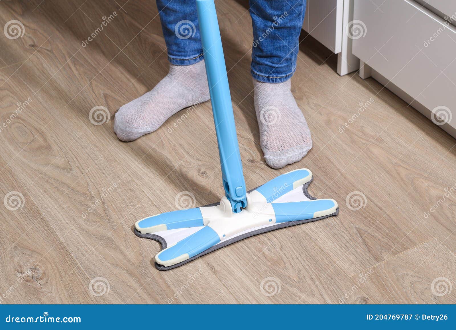 A Man Washes the Floors with a Mop in Room. Under the Bed. Cleaning