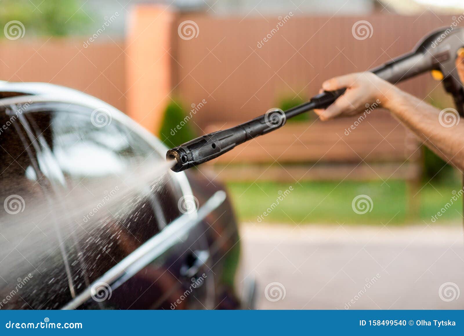 a man washes his car with a large head of water from a karcher on open air. close up photo