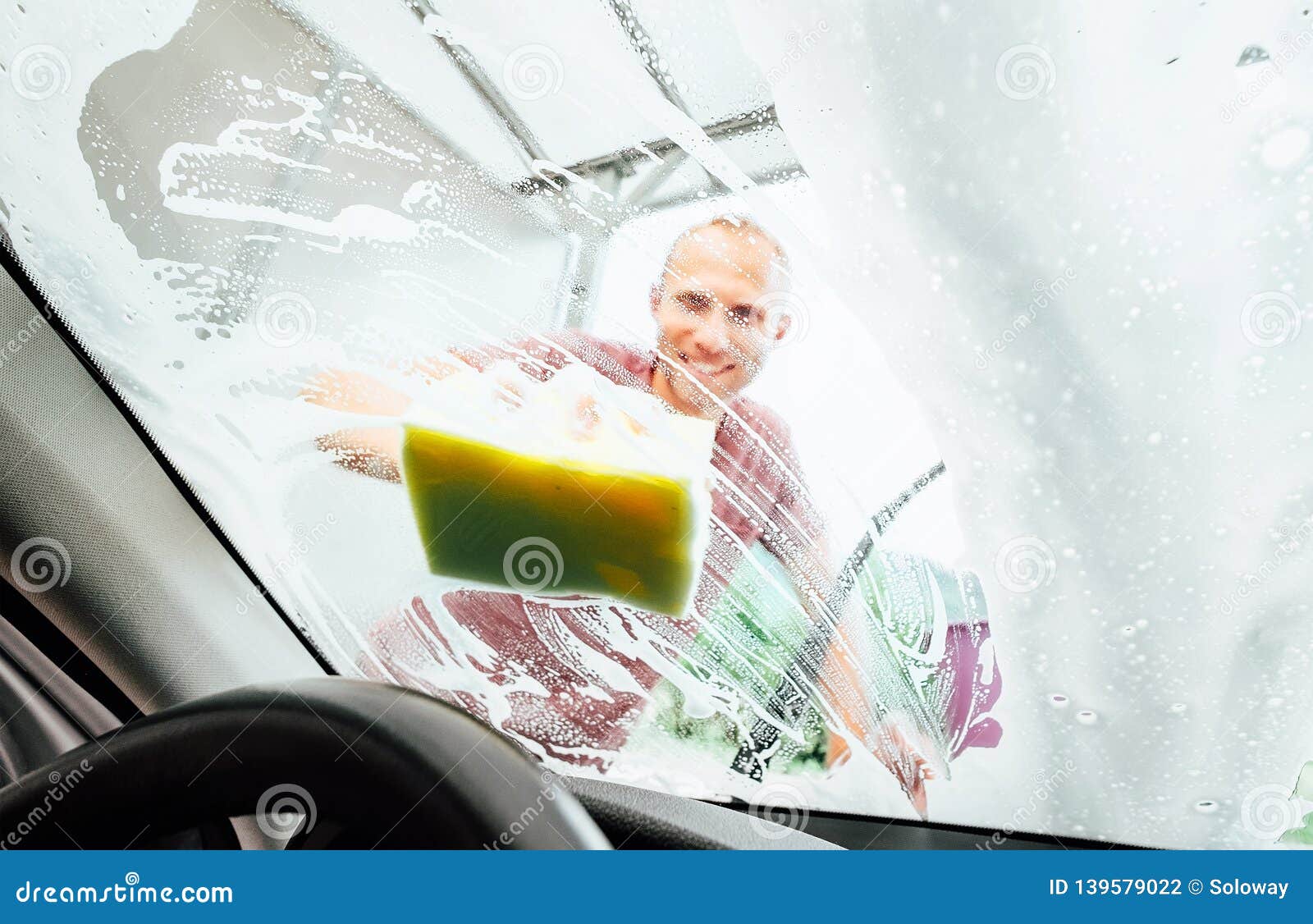 Man Washing His Car Windshield Window Inside the Car Camera View Stock