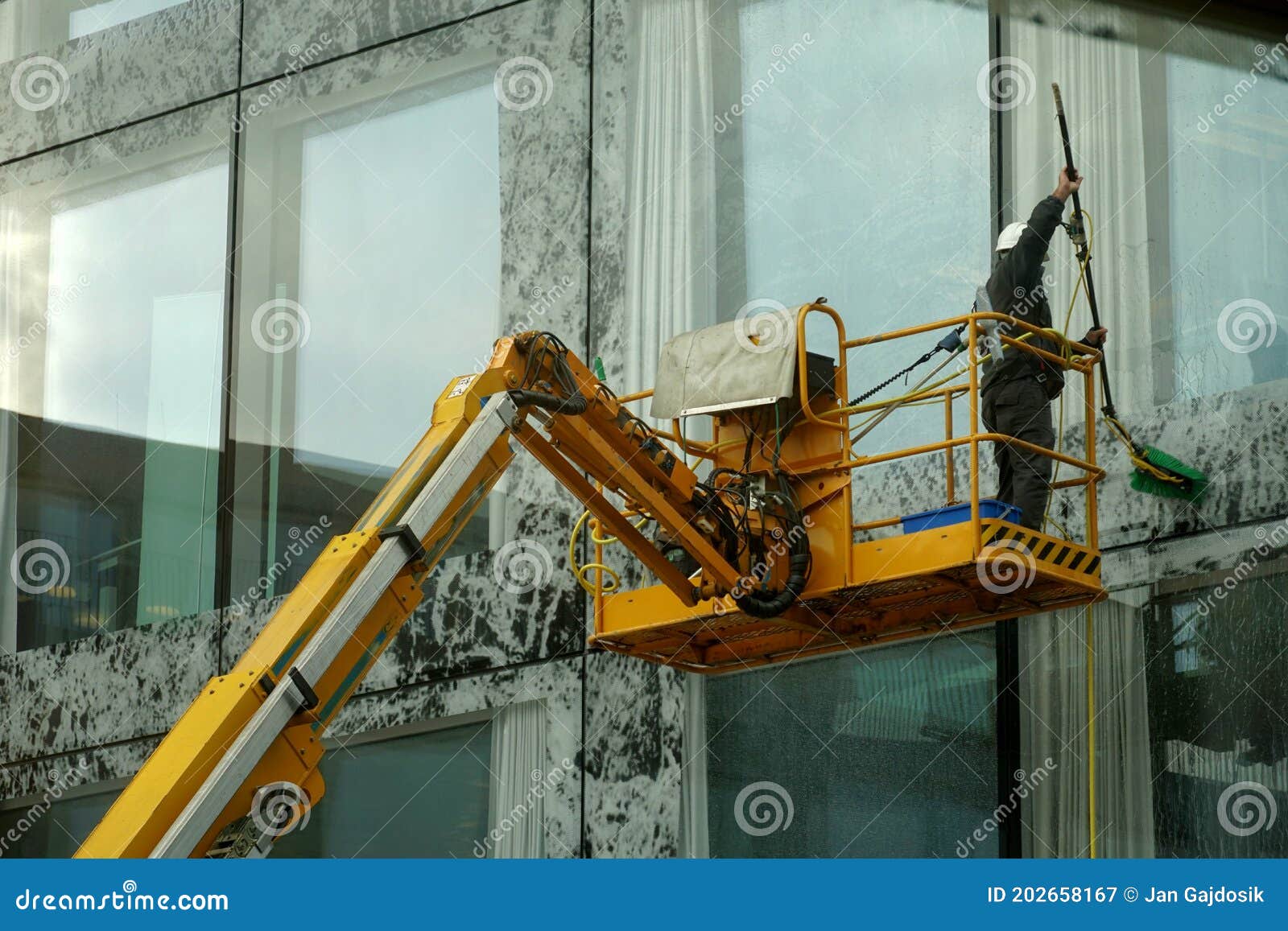 A Man Washing Large Windows and Facade of Tall Corporate Building with a Mop.  Editorial Photography - Image of machinery, industrial: 202658167