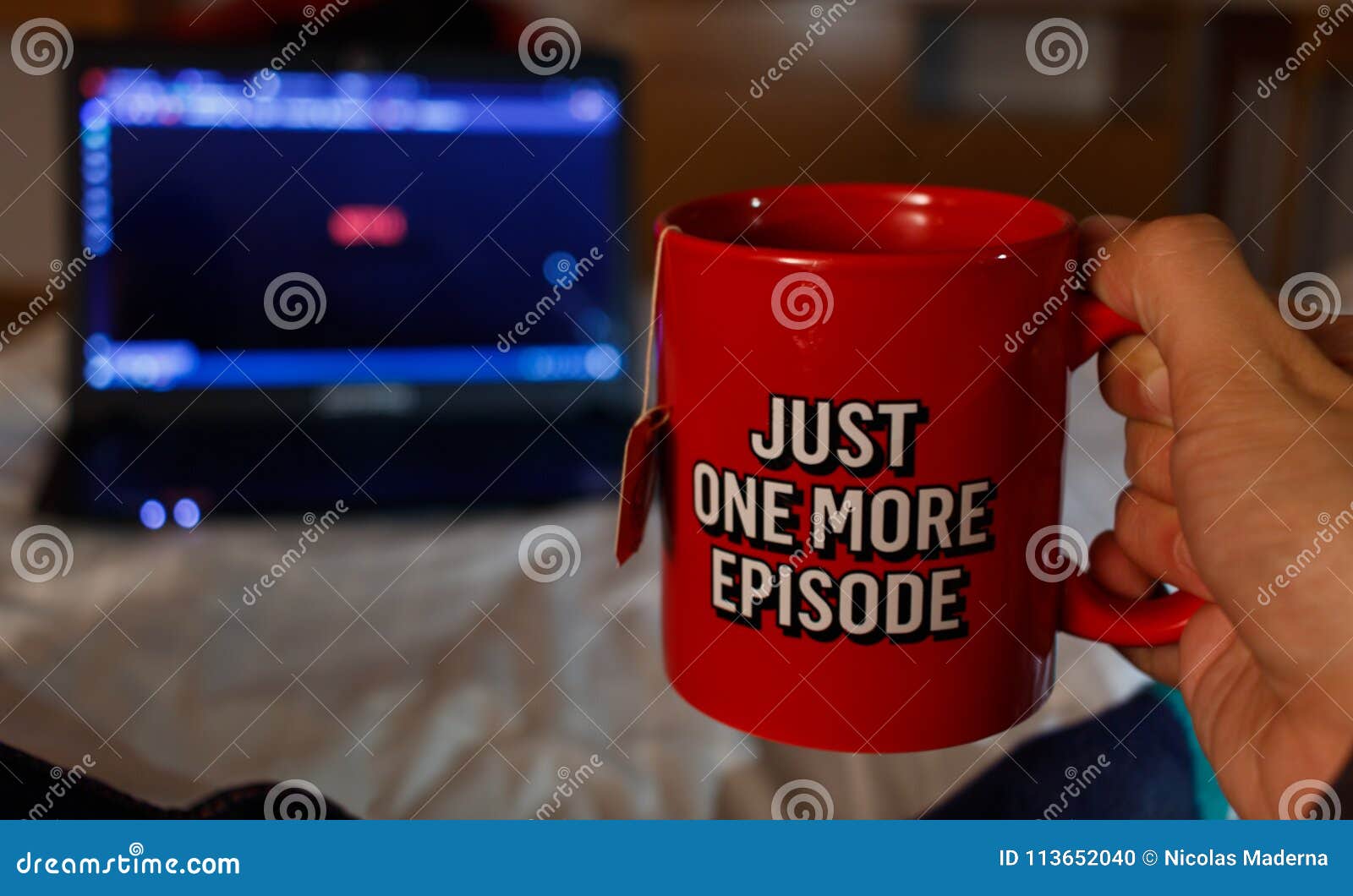 man watching series while holding with a cup of tea with netfix