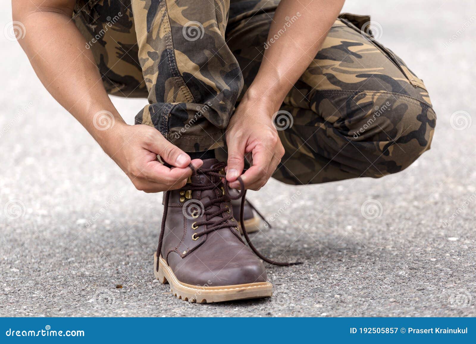 man wearing cargo pants tying laces leather shoes boot man wearing cargo pants tying laces leather shoes 192505857
