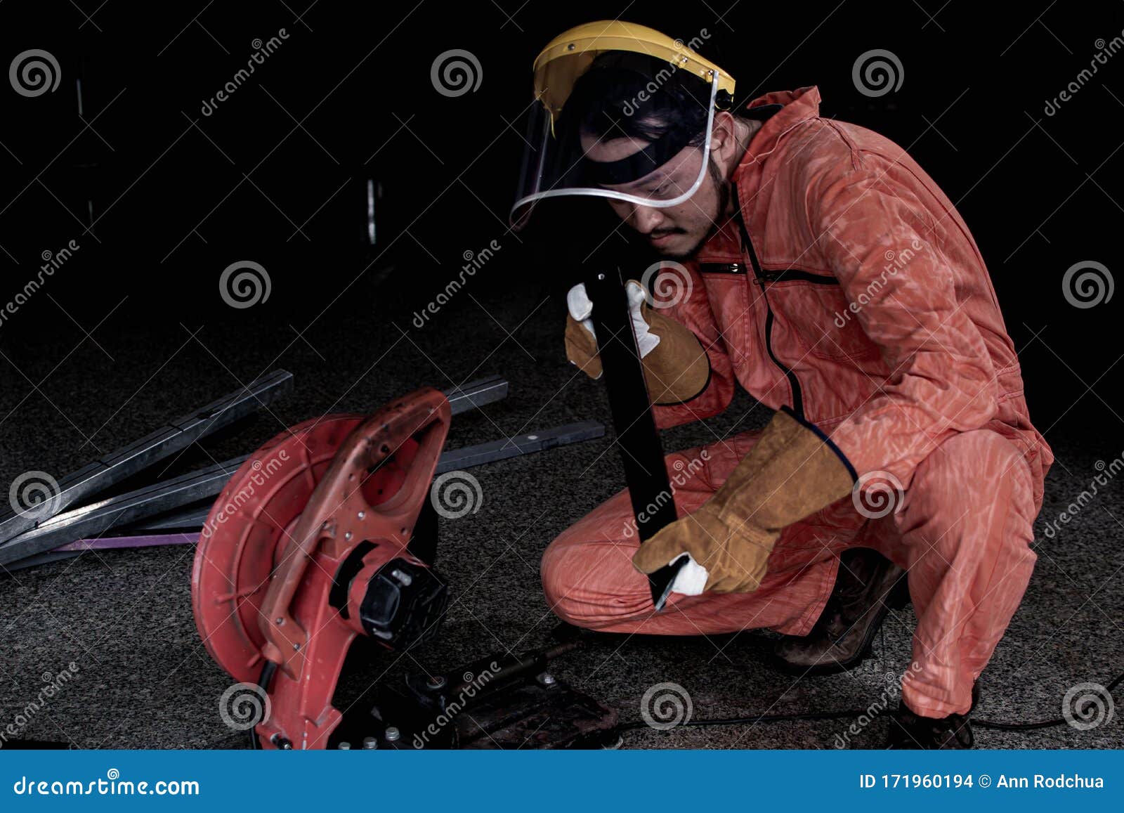 a man wearing safety mask and suit is cutting metal