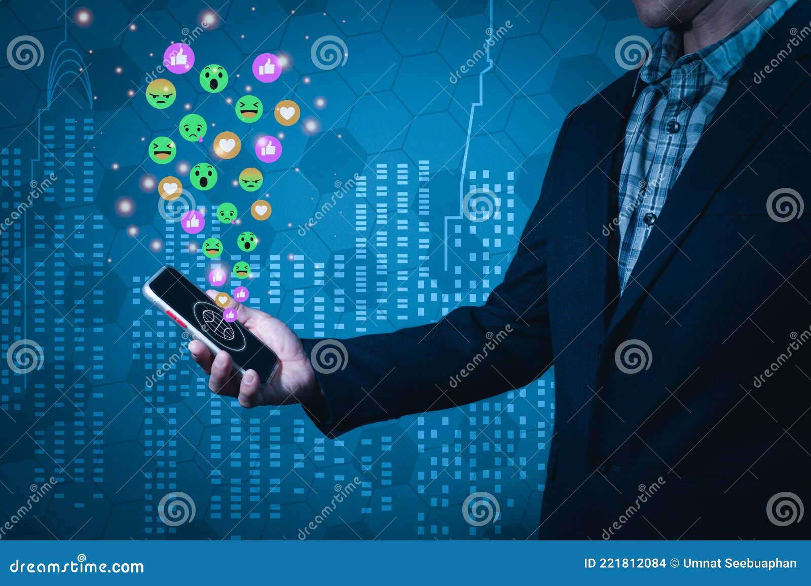 a man wearing a suit holds a mobile phone forwarded in a manner that reads a message on the screen. there are emojis emitting from