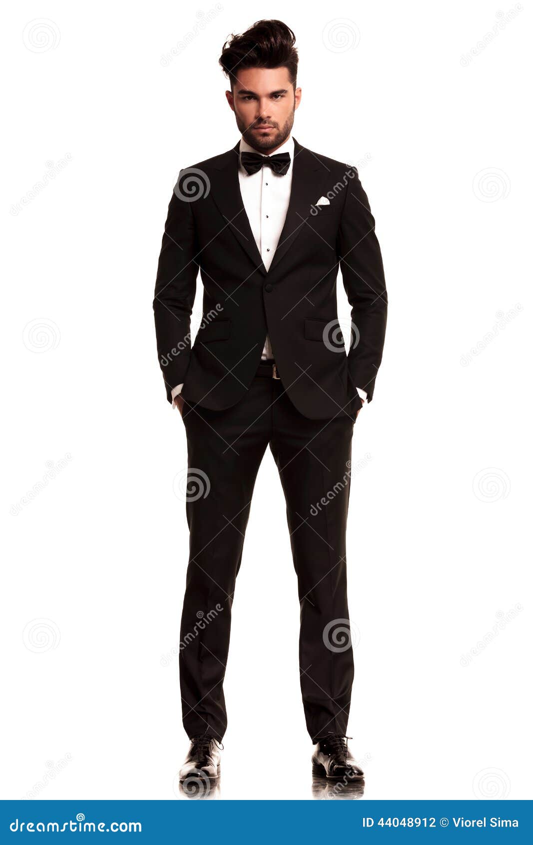 man wearing tuxedo standing with hands in pockets