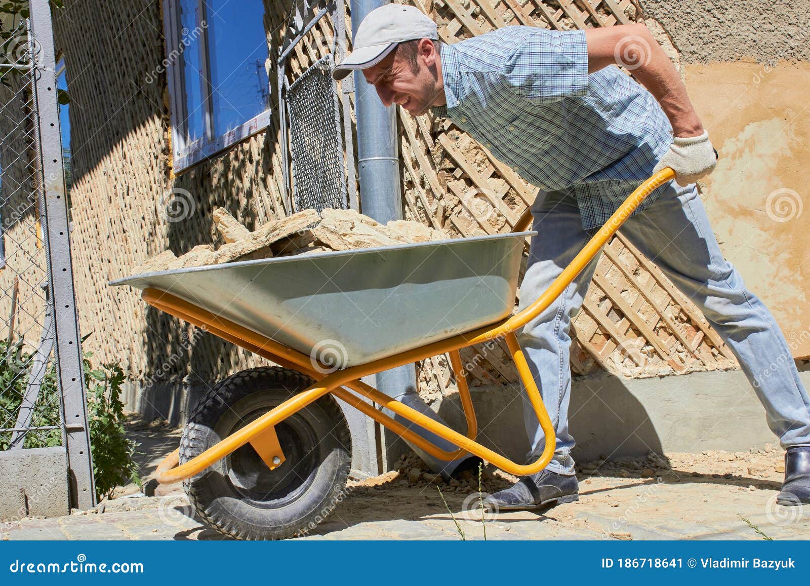 Man with a Wheelbarrow at a Construction Site,hard Work of a Builder