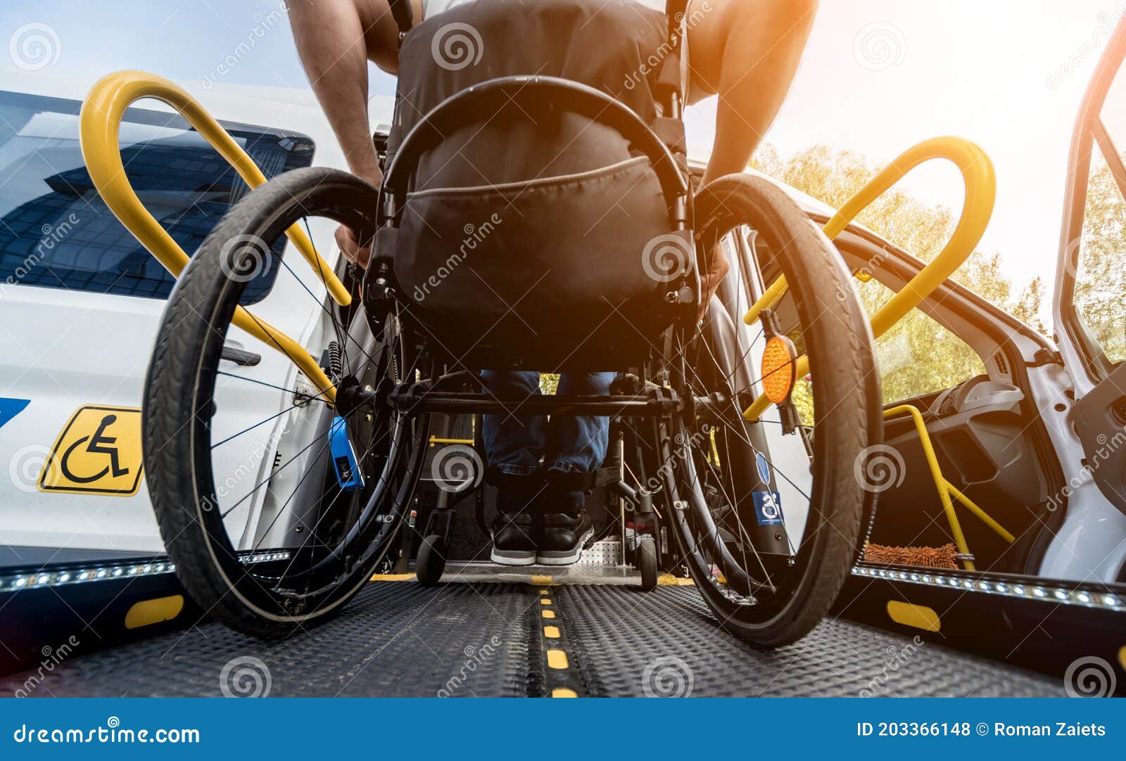 a man in a wheelchair on a lift of a vehicle for people with disabilities