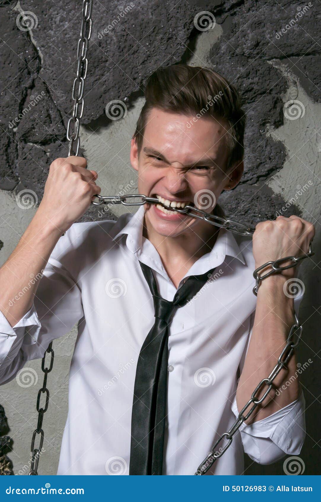 A Man in a White Shirt and Tie Breaks the Chain Teeth. Stock Image
