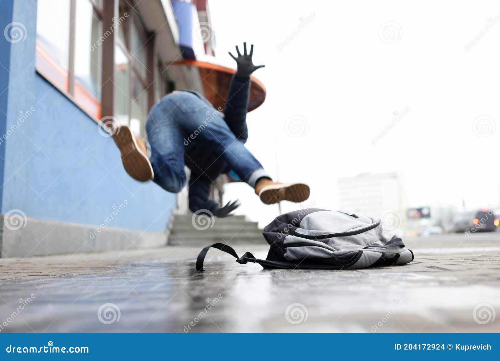 man in winter dress slip on sidewalk with ice closeup background