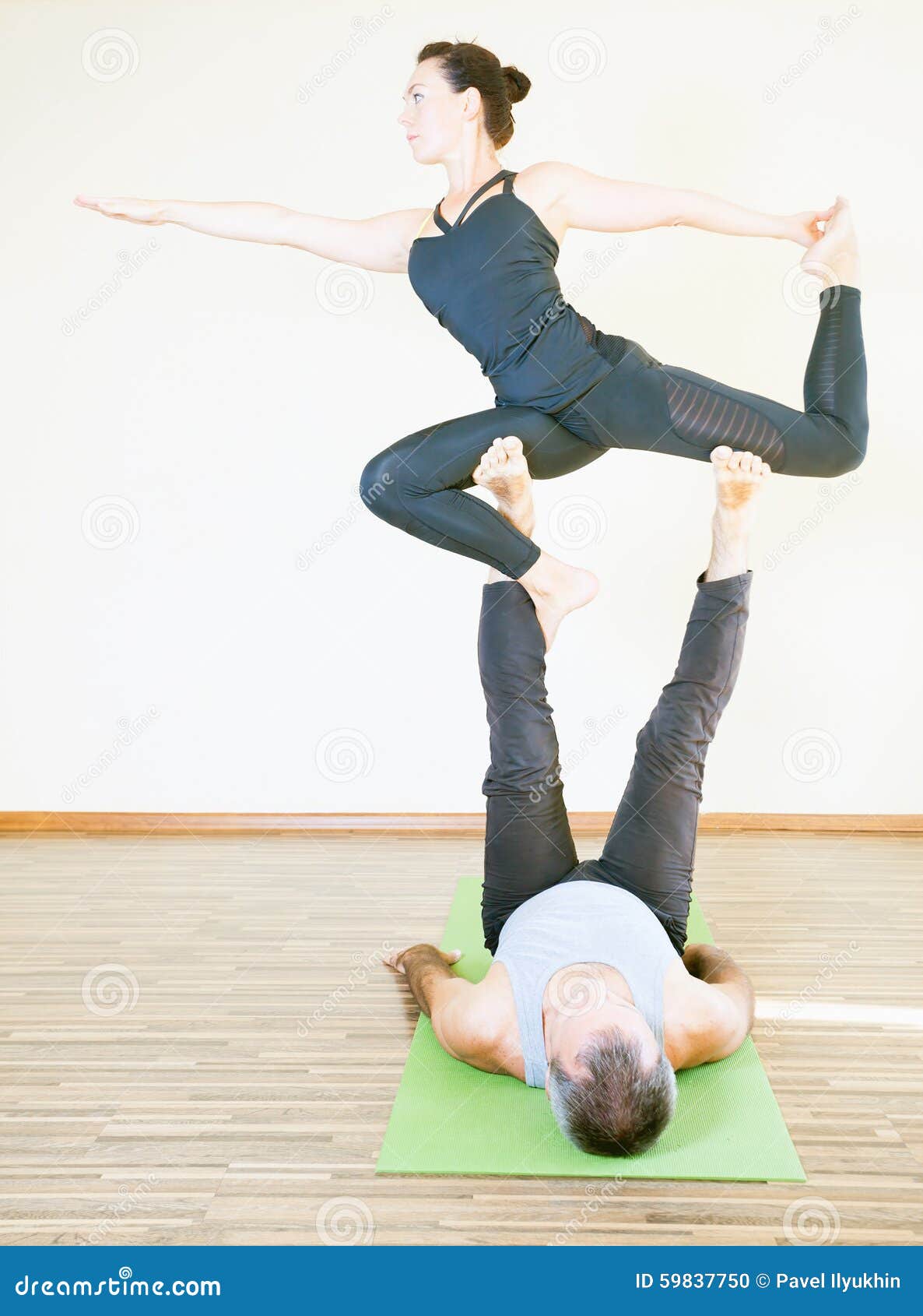 Man and Woman Doing Acro Yoga or Pair Yoga Indoor Stock Photo