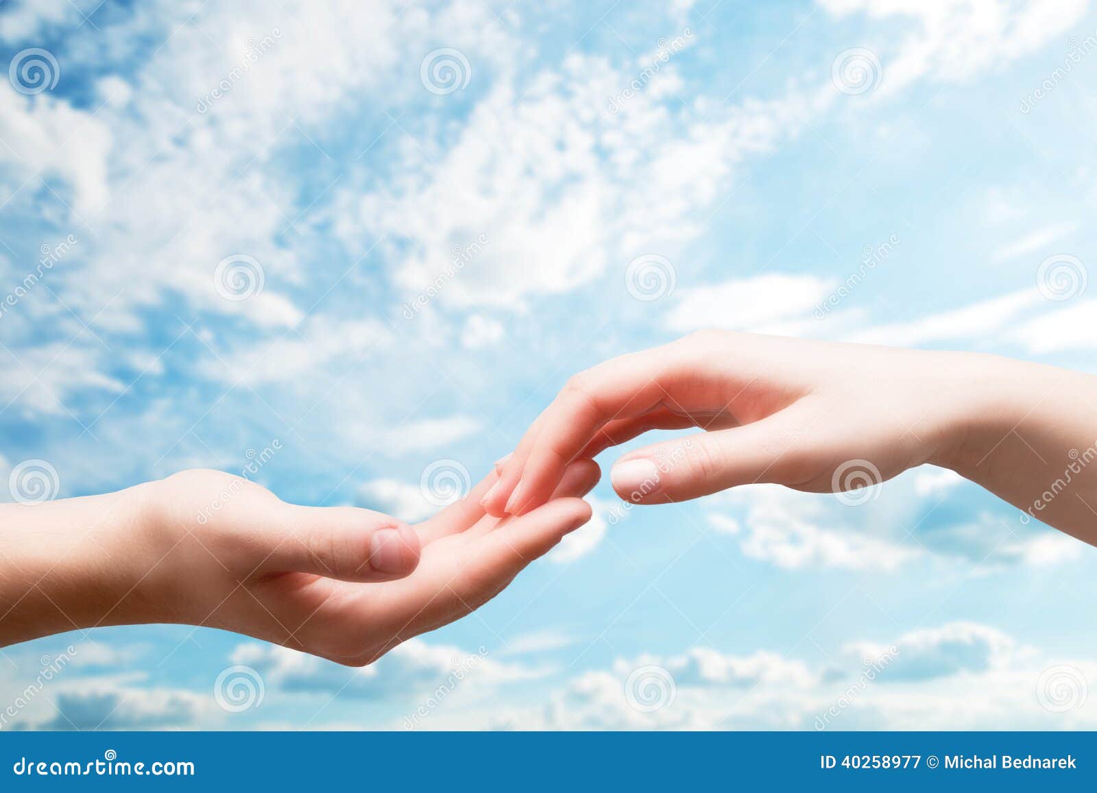 man and woman hands touch in gentle, soft way on blue sunny sky