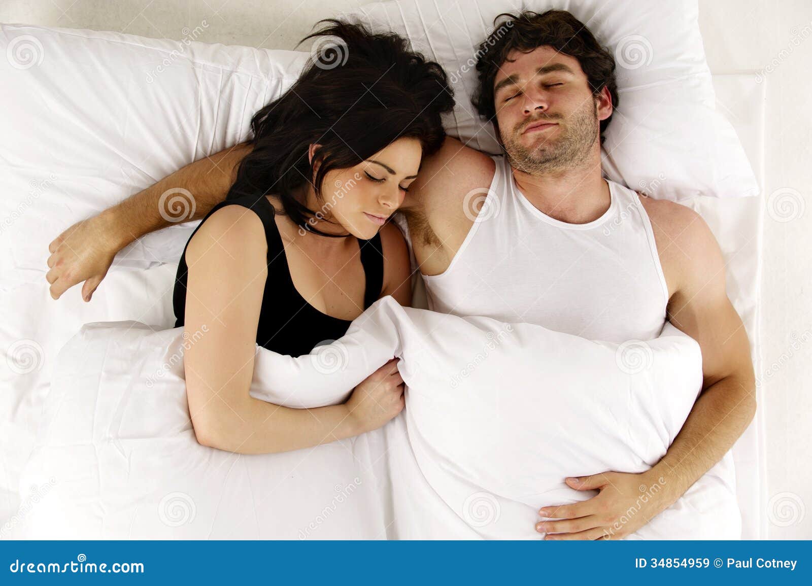 Man And Woman Laid In White Bed Asleep Cuddling Stock Image