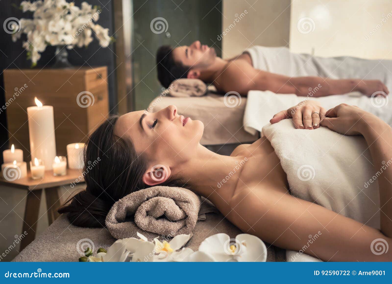 man and woman lying down on massage beds at asian wellness center