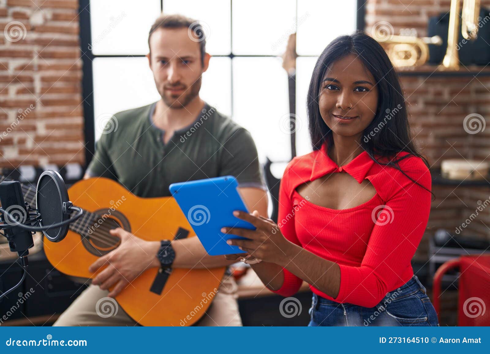 Man and Woman Musicians Playing Classical Guitar Using Touchpad at Music Studio Stock Photo
