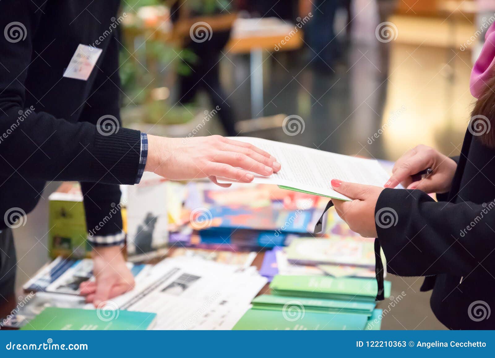 man and woman sharing information leaflet over exhibition stand