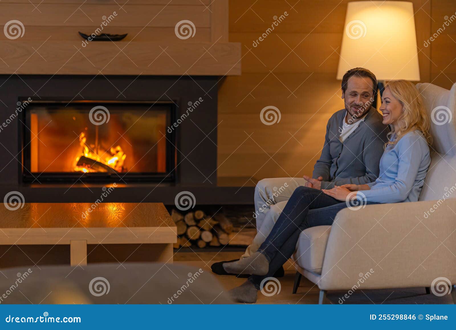 The Man and Woman Sitting Near the Fireplace. Stock Photo Image of