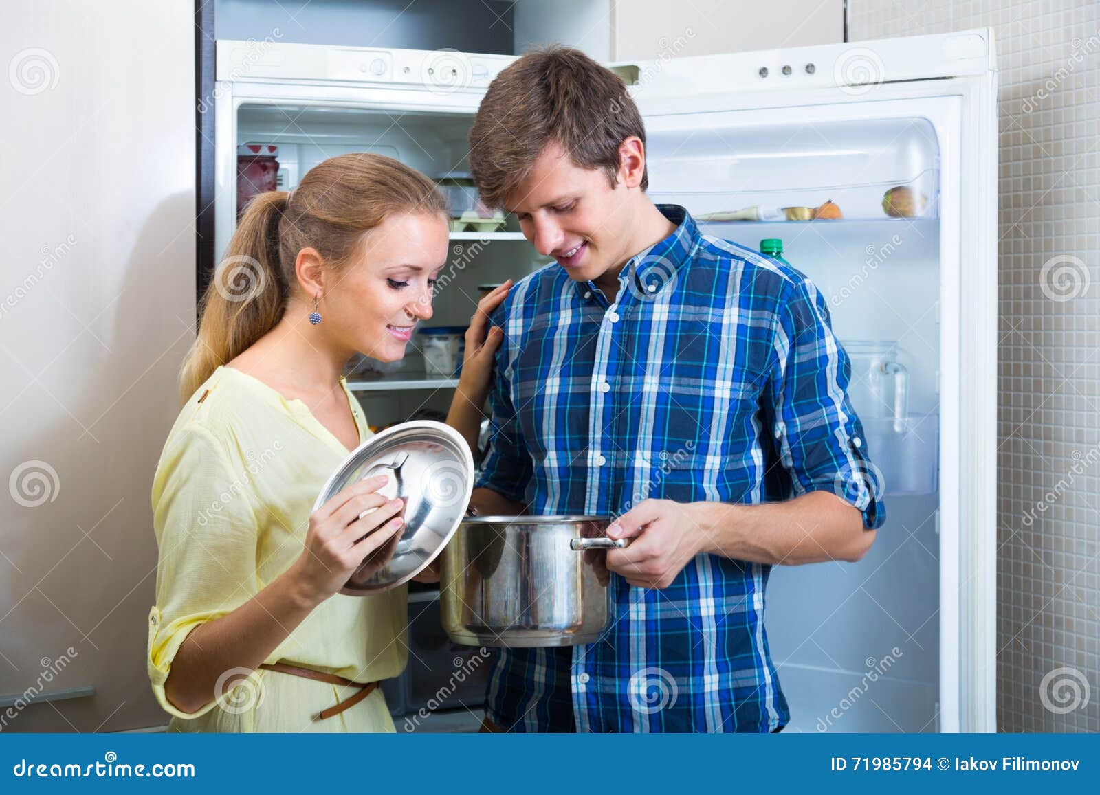 man and woman standing near fridge