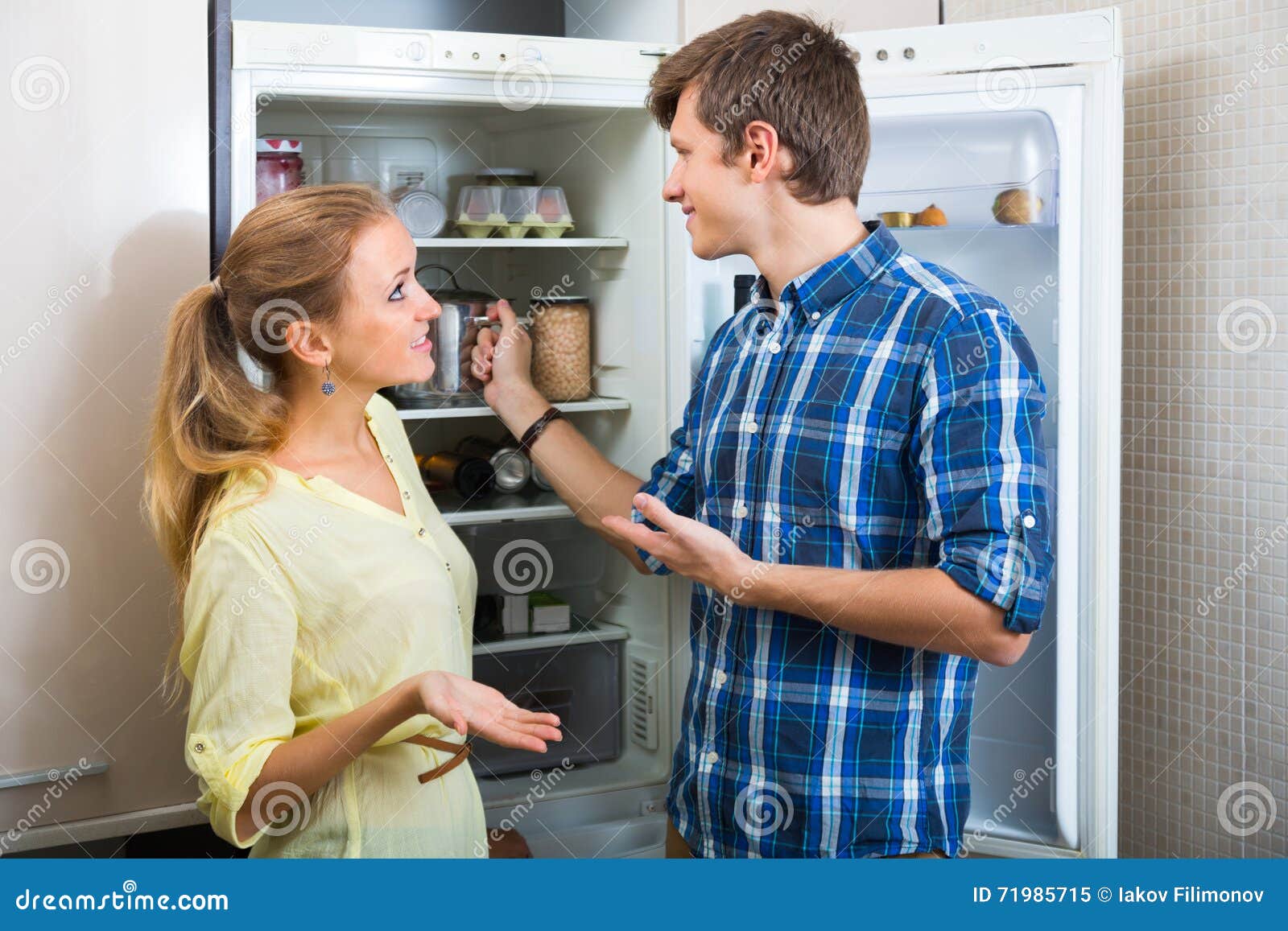 man and woman standing near fridge