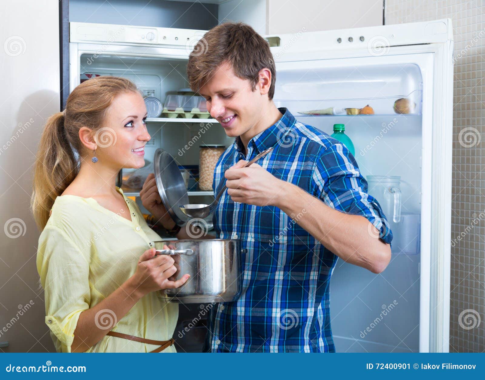 man and woman standing near fridge