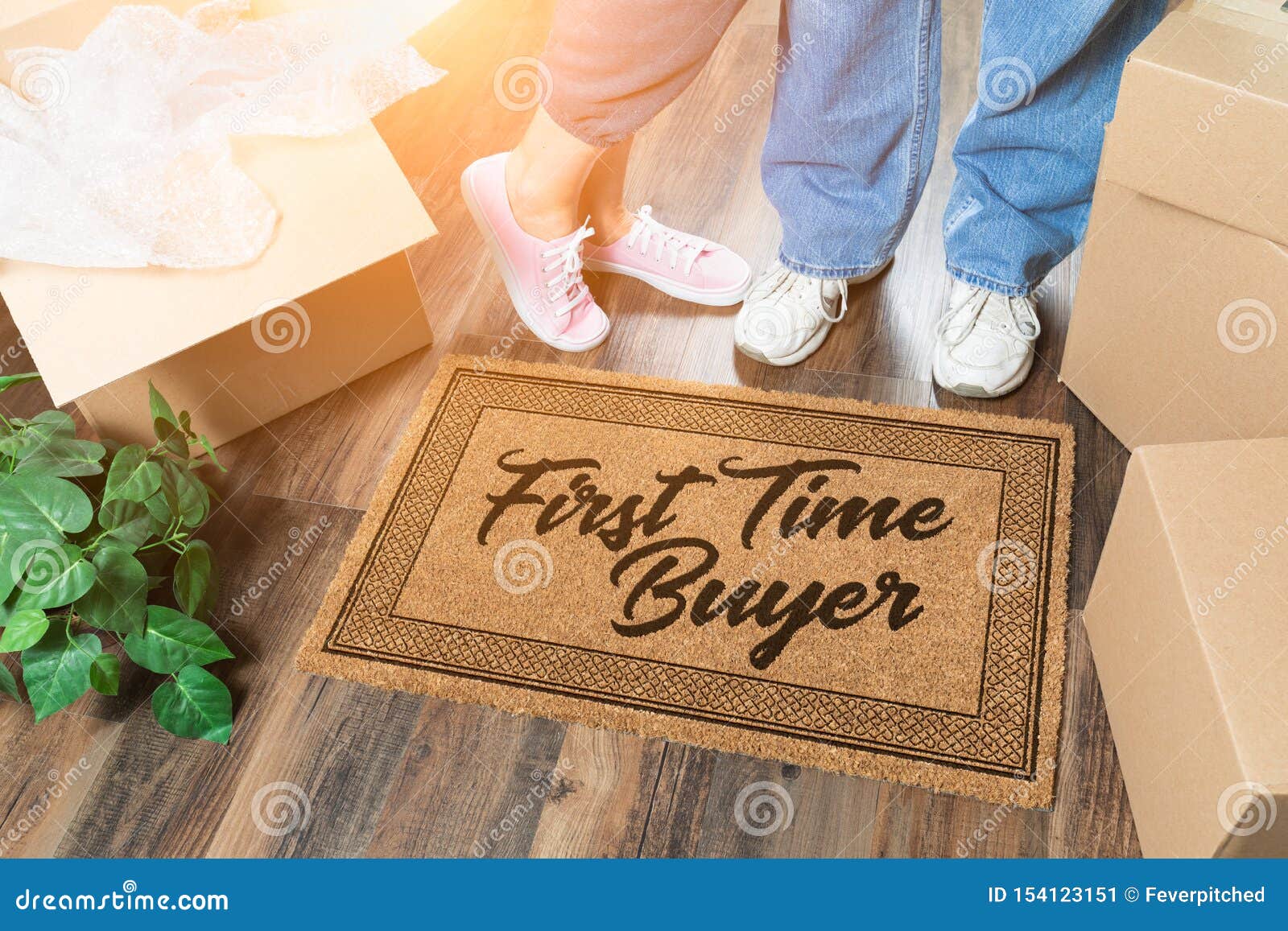 man and woman unpacking near our first time buyer welcome mat, moving boxes and plant