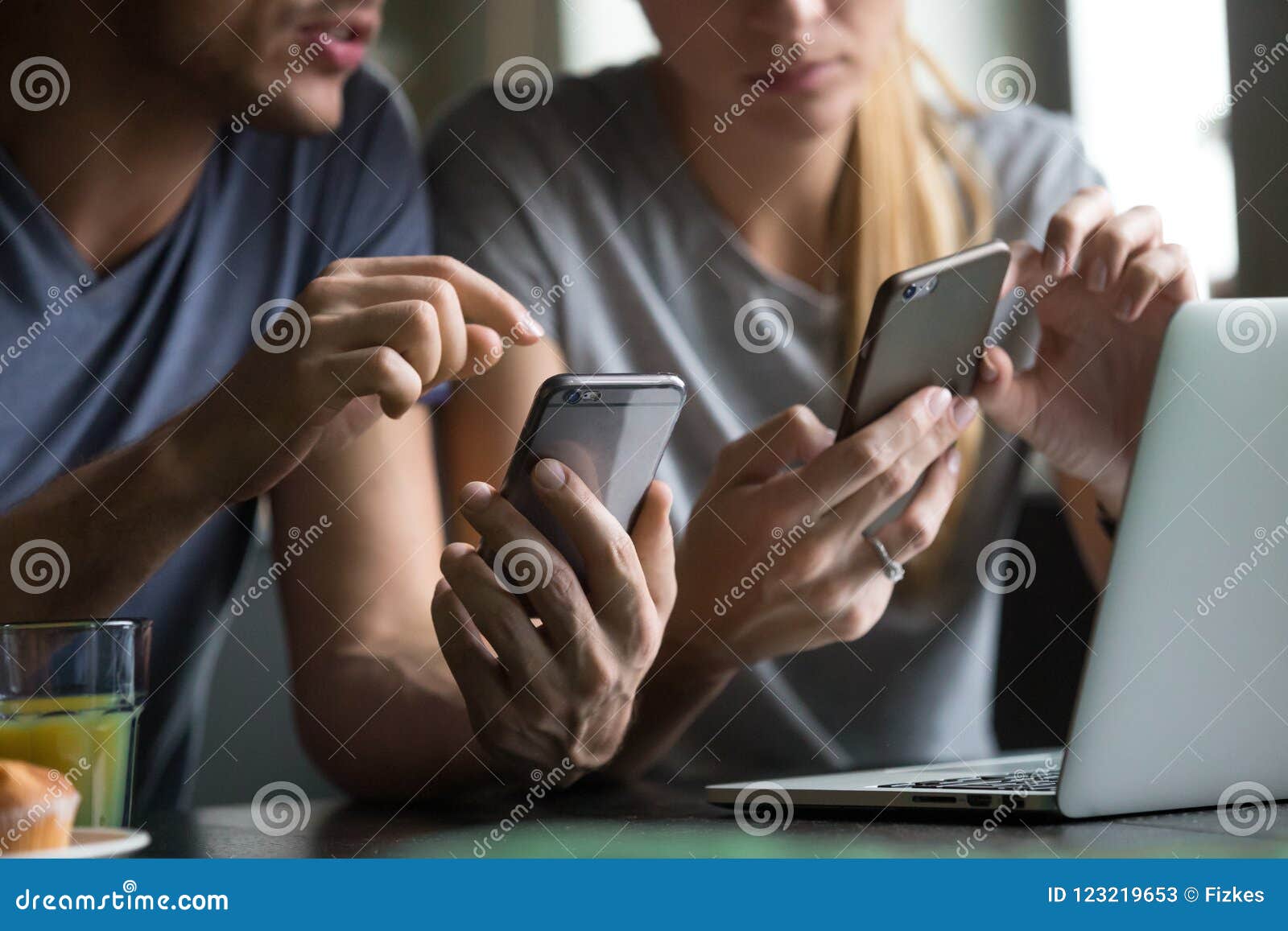 man and woman using smartphones discussing mobile apps, close up