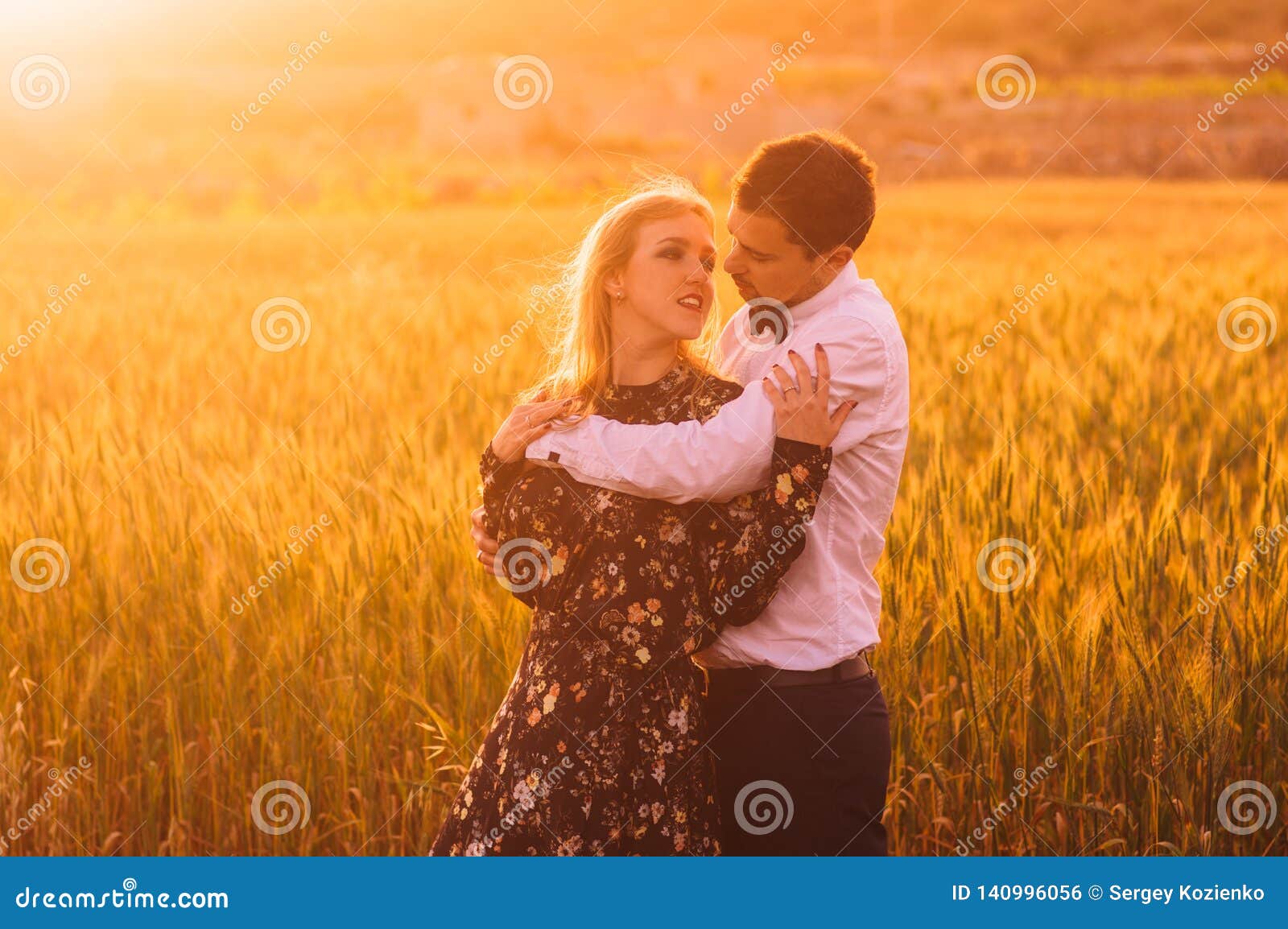 Man and woman embracing in poppy field on the dusk. Man and women embracing in poppy field on the dusk, countryside Malta