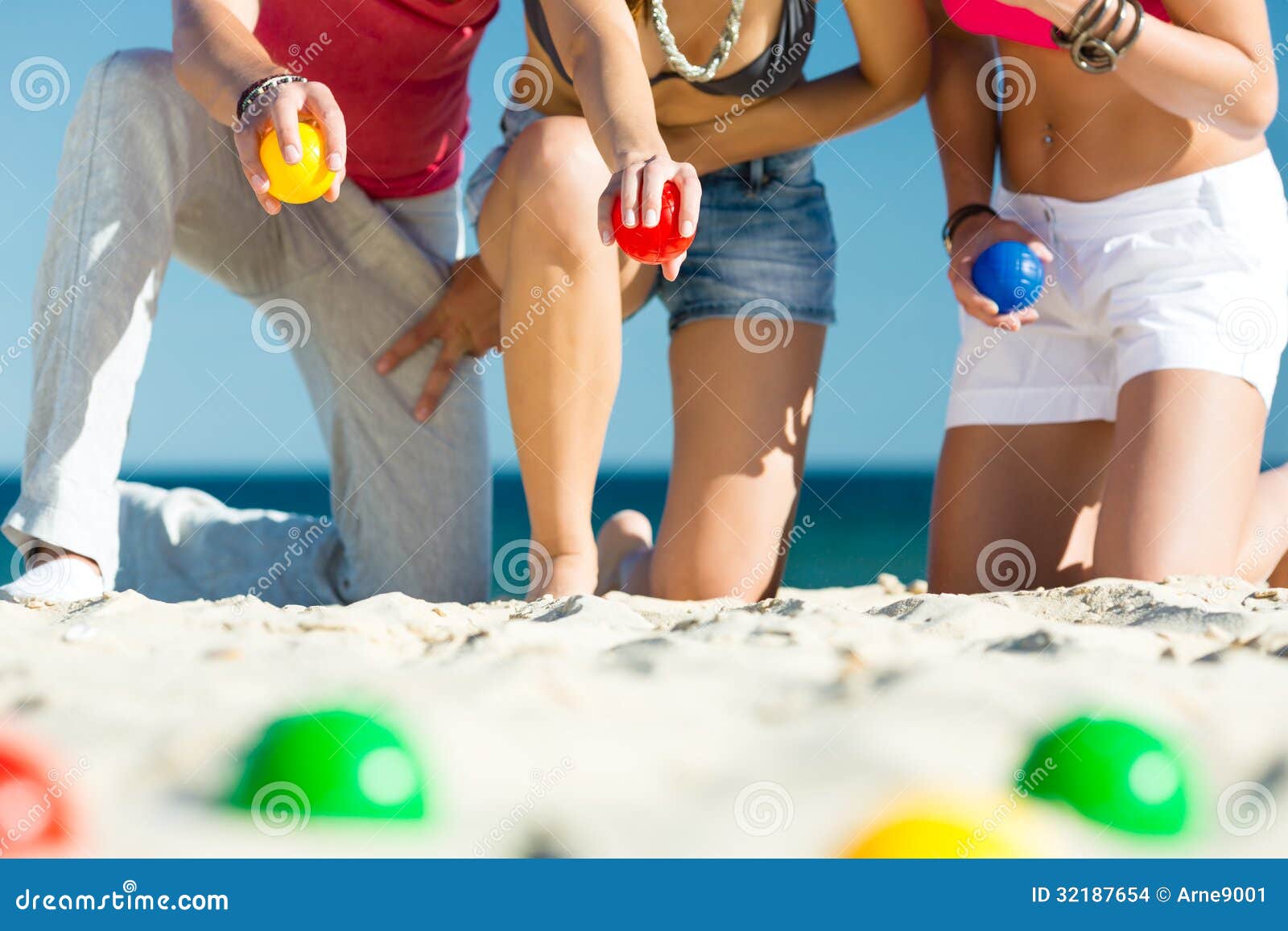 man and women playing boule on beach