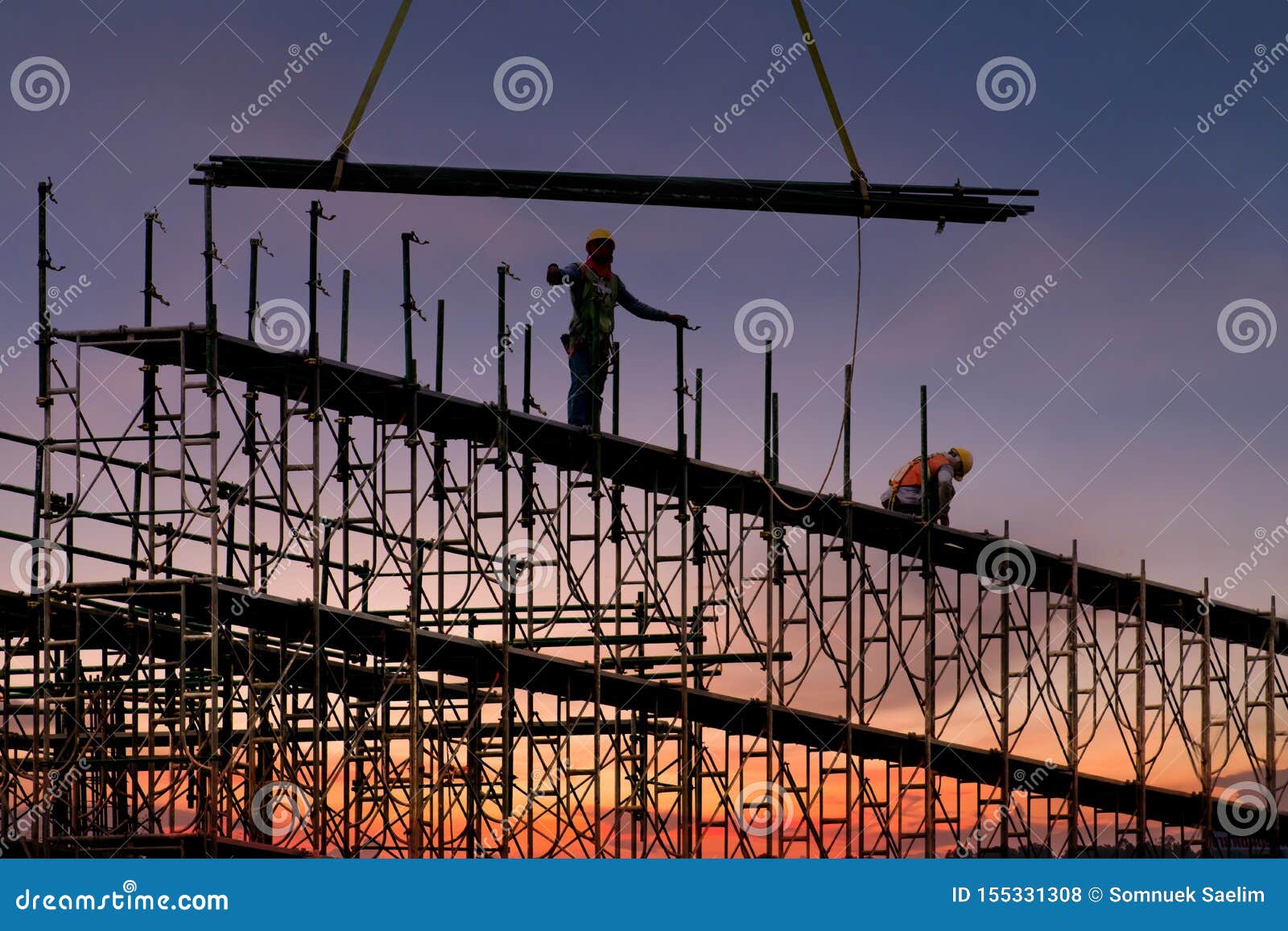 man working on construction site with scaffold and building with sunset background,scaffolding for construction factory