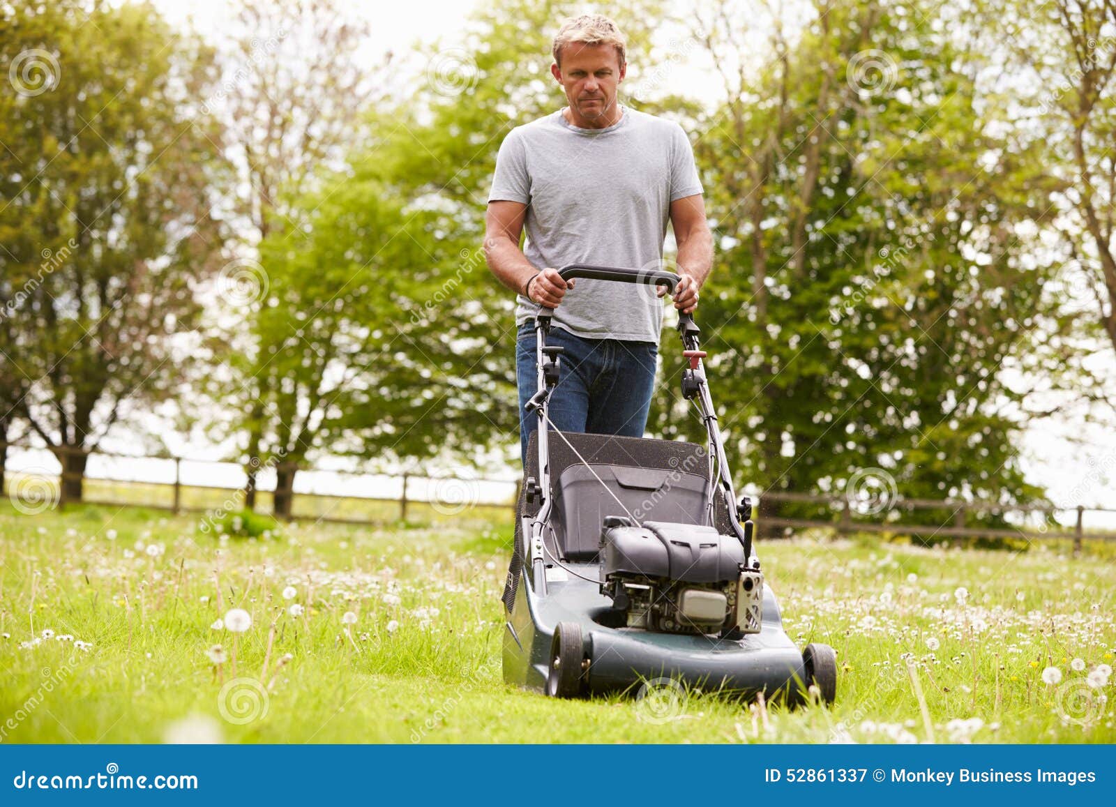 Man Working In Garden Cutting Grass With Lawn Mower Stock Photo Image