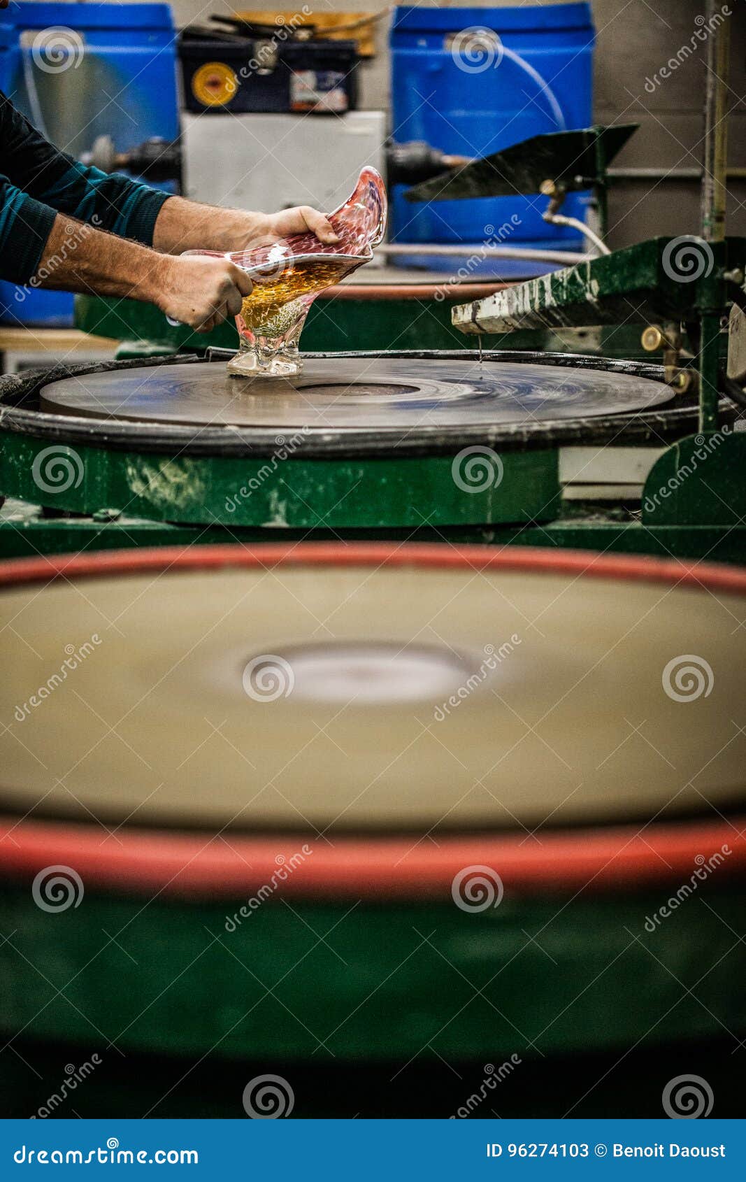 man working a glass blown vase on silica sanding disk