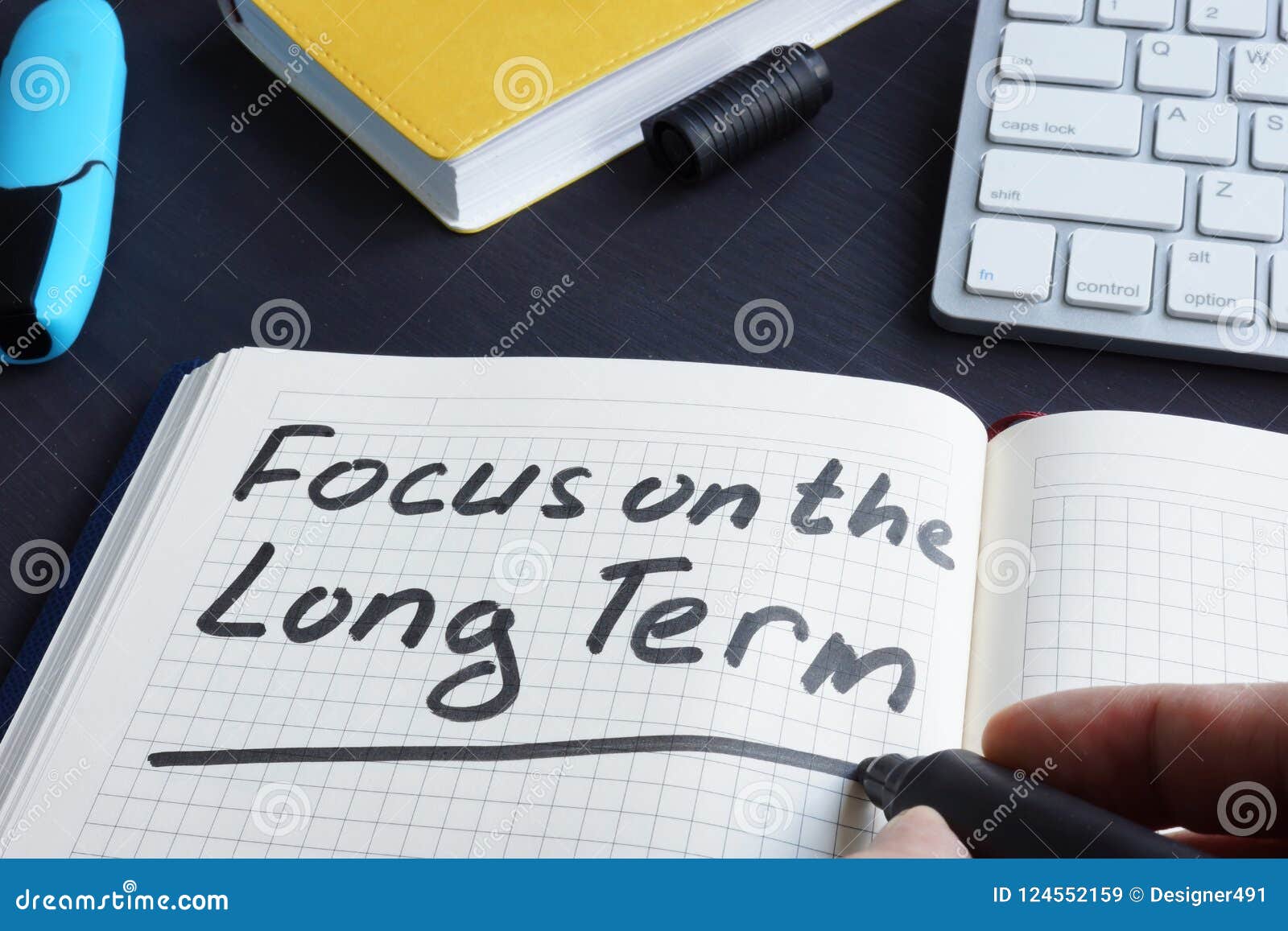 man is writing focus on the long term.