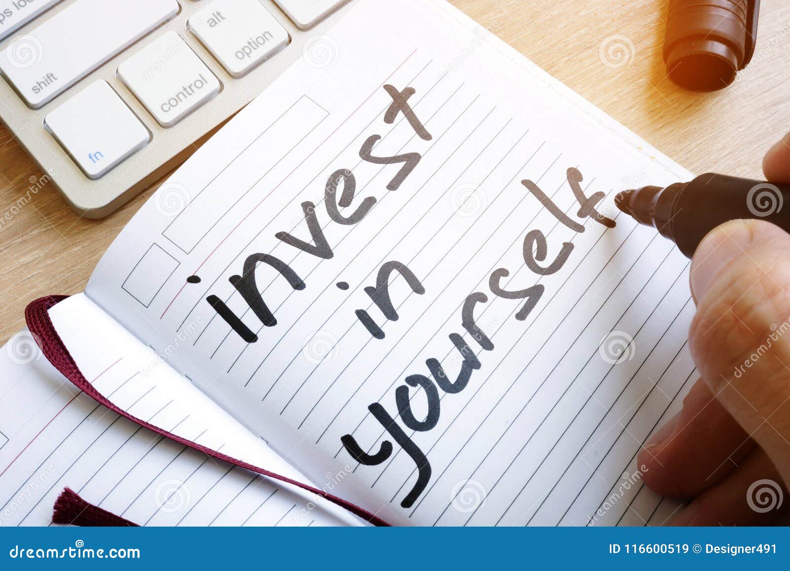 man is writing invest in yourself.