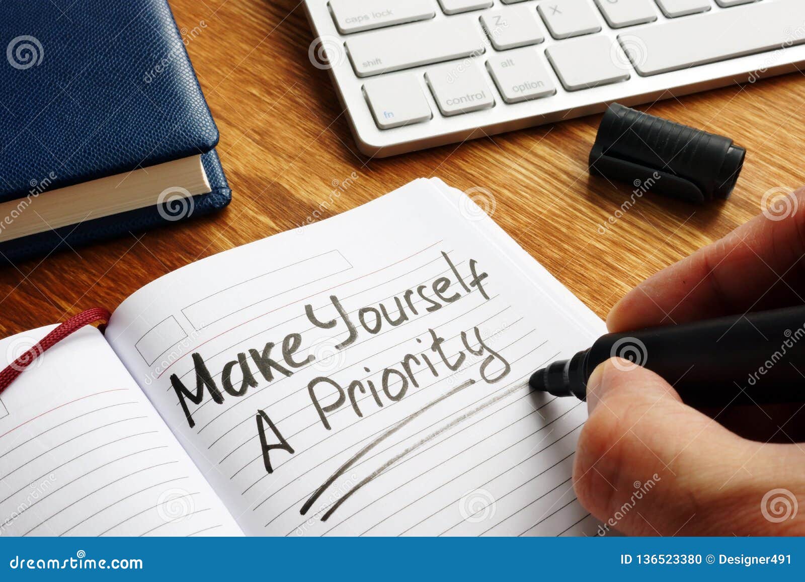 man is writing make yourself a priority