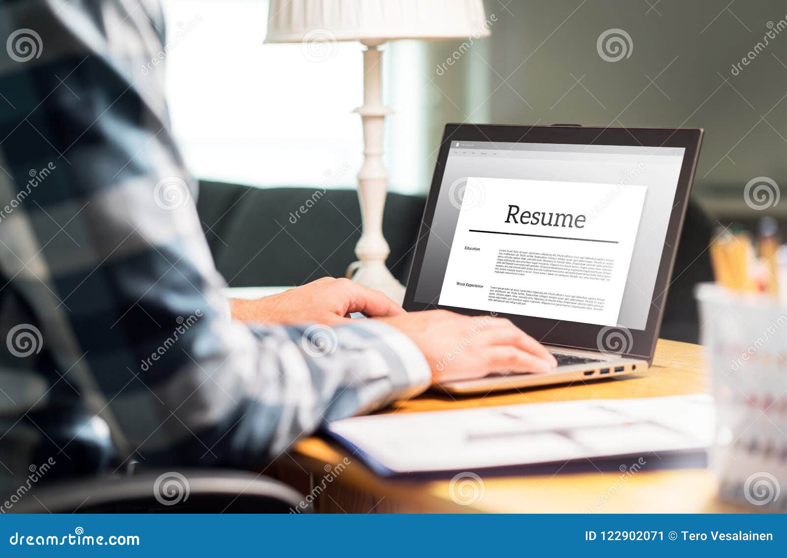 man writing resume and cv in home office with laptop